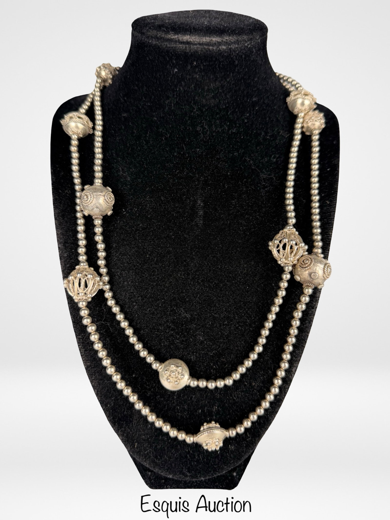 Sterling Silver Beaded Filligree Station Necklace: Elegant long sterling silver station necklace featuring a continuous strand of polished bead links accented with ornate filigree orb stations. The decorative elements are evenly spaced along the