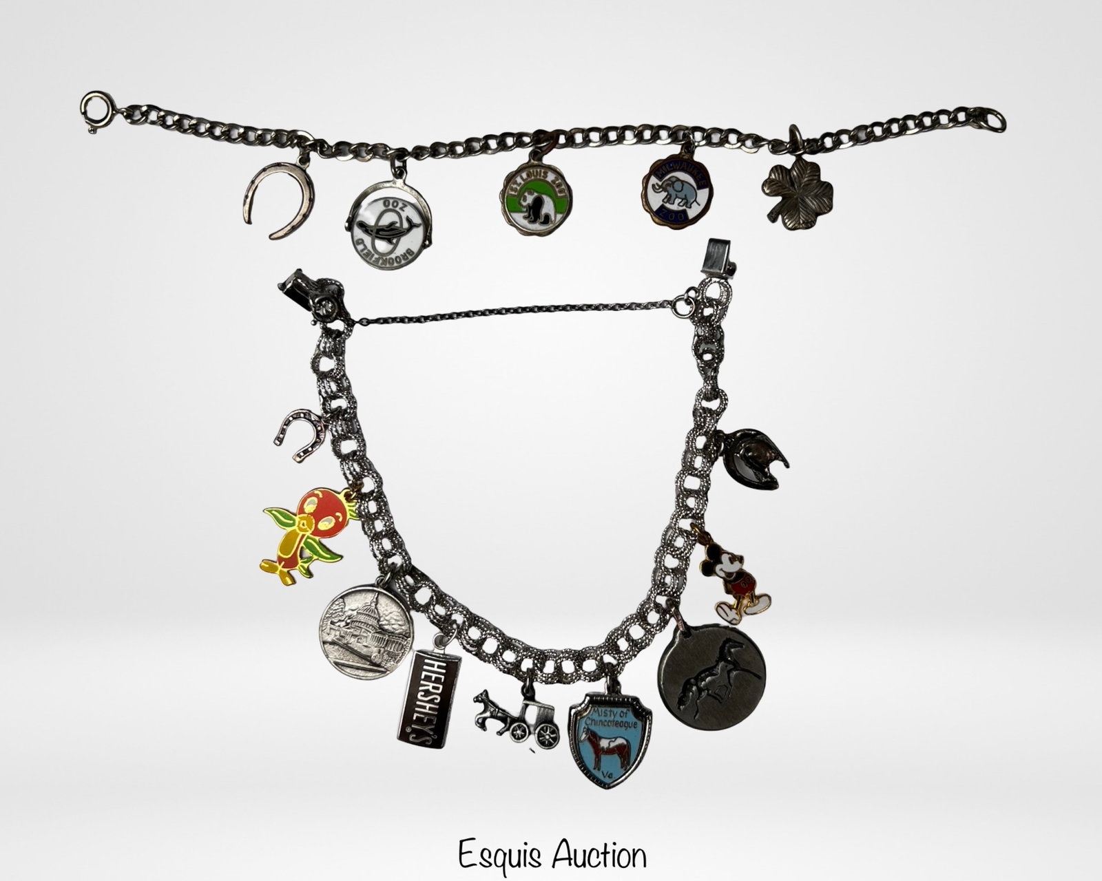 Two Vintage Sterling Silver Charm Bracelets: Pair of vintage sterling silver charm bracelets featuring an eclectic mix of souvenir and novelty charms. Charms include travel and attraction themes such as Brookfield Zoo, Kentucky Horse Park,