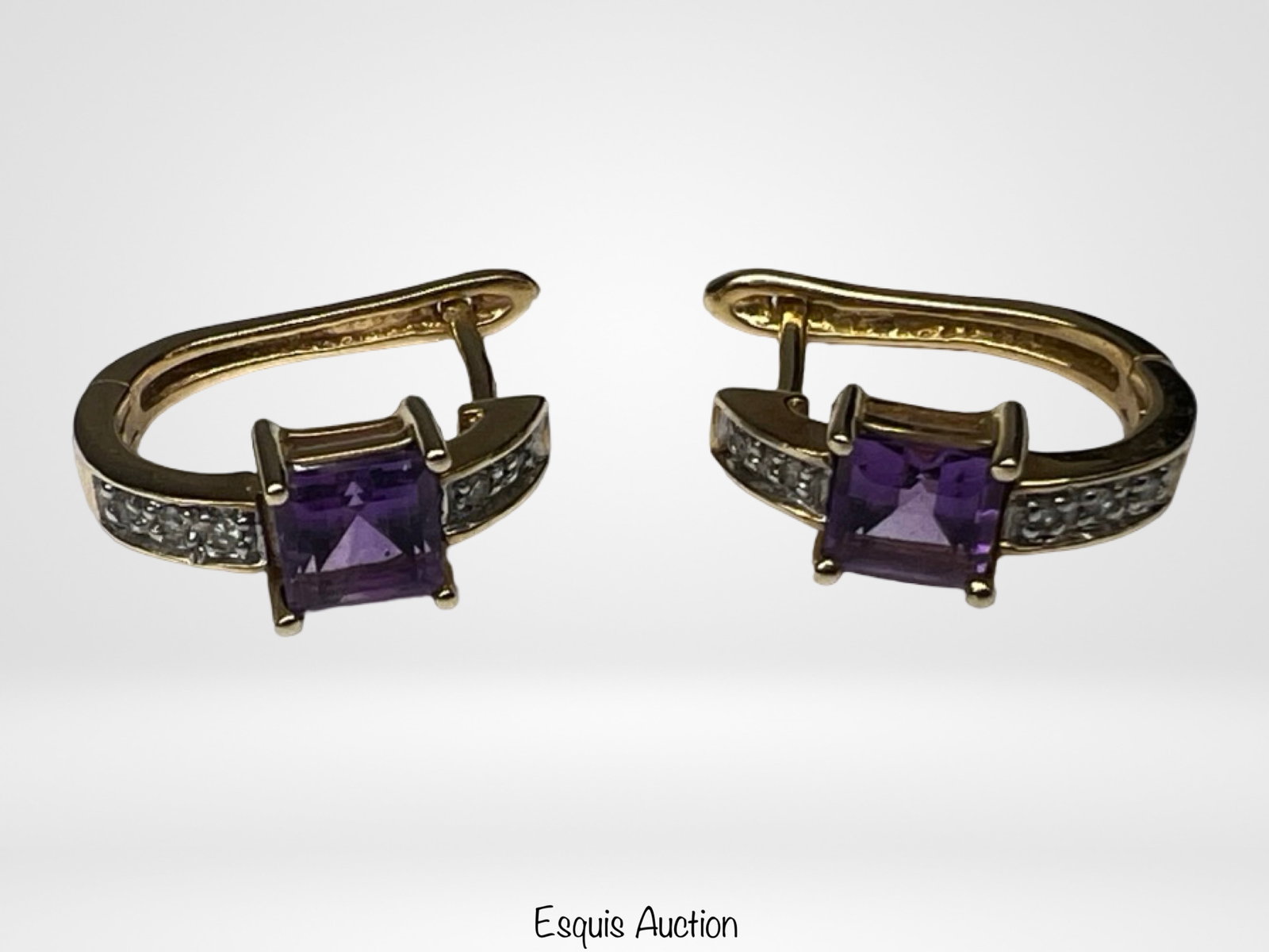 10K Gold Amethyst & Diamond Accent Hoop Earrings: Elegant pair of 10K yellow gold hoop earrings set with square-cut amethyst gemstones in a rich purple hue. Each earring features a central prong-set amethyst, complemented by small diamond accent ston