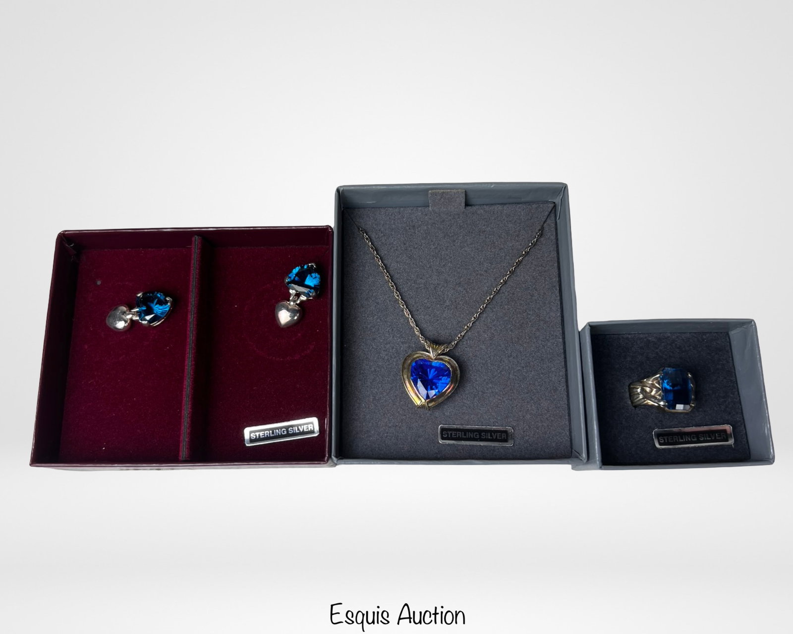 Sterling Silver Blue Heart Jewelry Set: Elegant sterling silver jewelry set featuring a vibrant blue heart motif, including a necklace, matching earrings, and coordinating ring. Each piece is set with faceted heart-shaped blue stones that