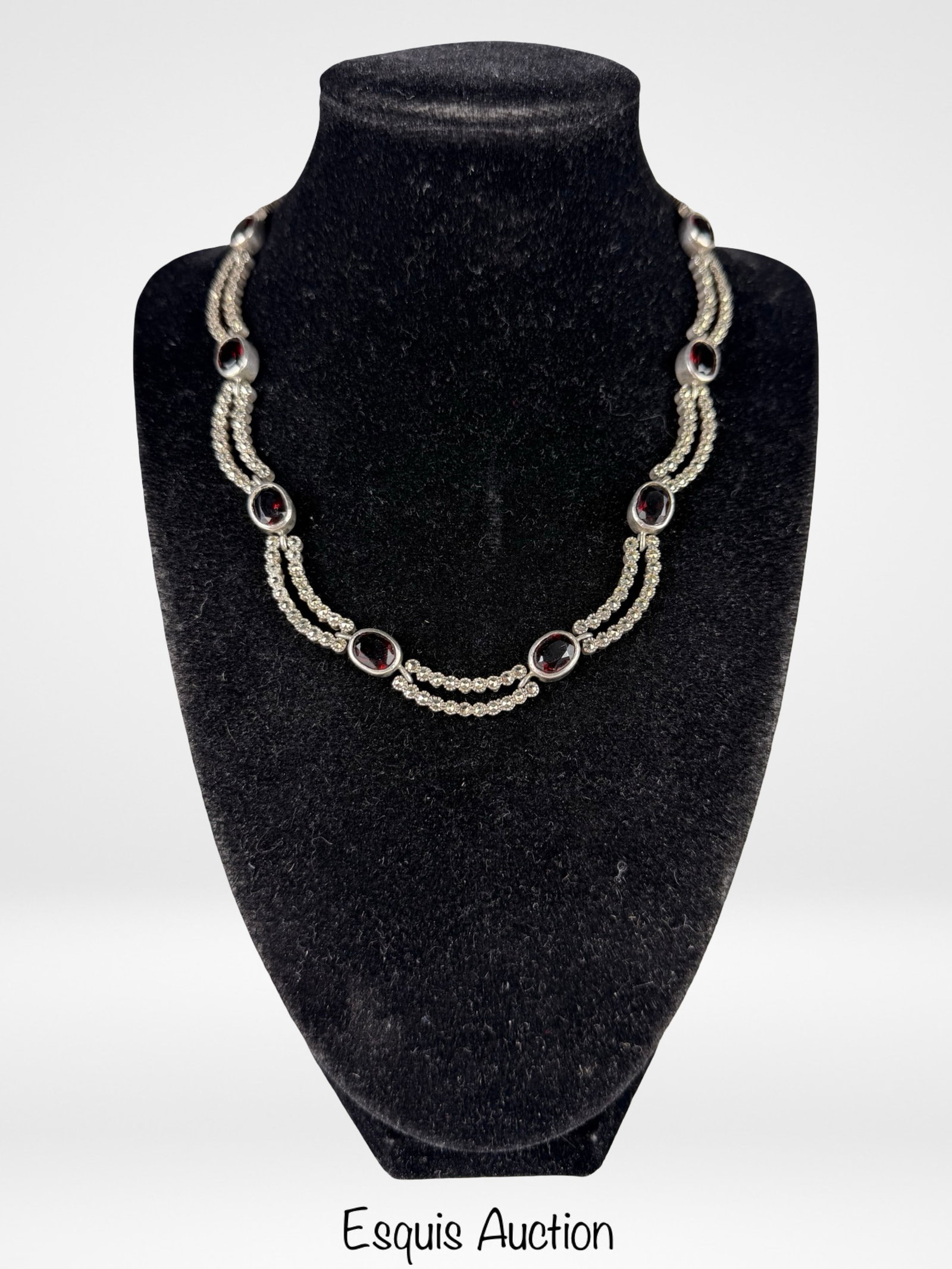 Sterling Silver Garnet & Marcasite Necklace: Elegant vintage sterling silver necklace featuring a refined design of oval-cut deep red garnet stones set at intervals along double strands accented with sparkling marcasite. The rich garnet color