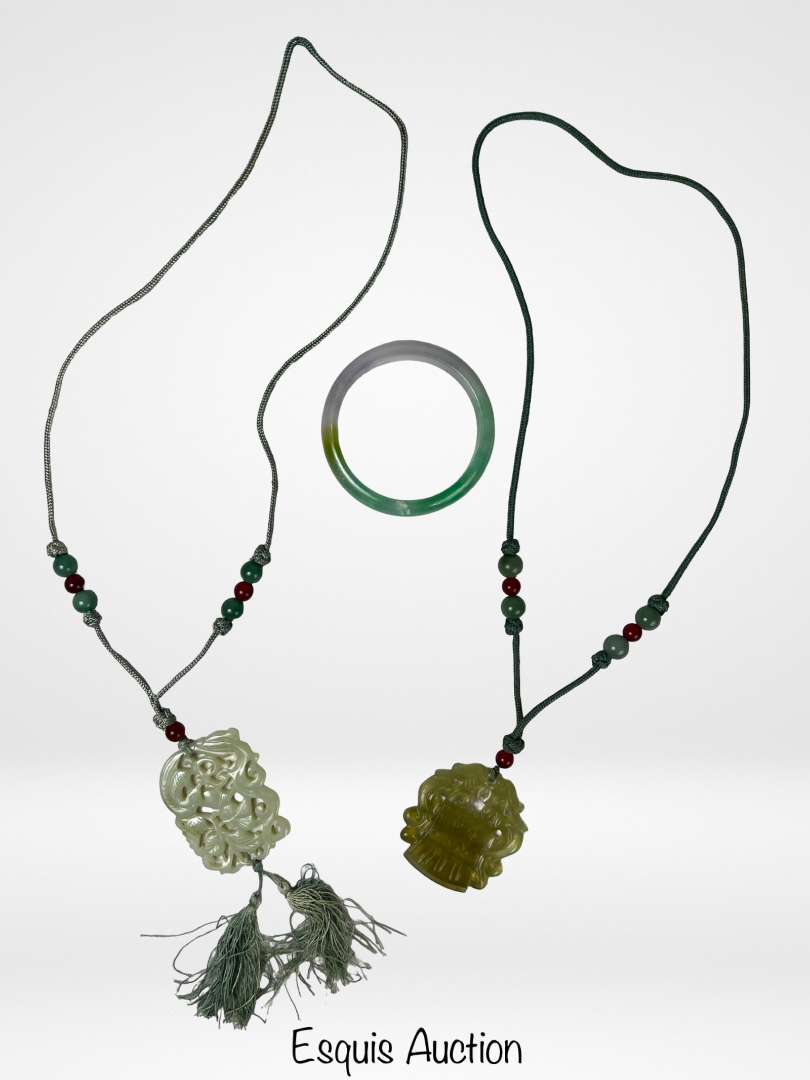 Chinese Jade Pendant Necklaces & Jadeite Bangle: ollection featuring a tricolor jadeite bangle bracelet together with two Chinese necklaces adorned with carved jade pendants. Includes an openwork pale celadon jade pendant with tassel decoration and 