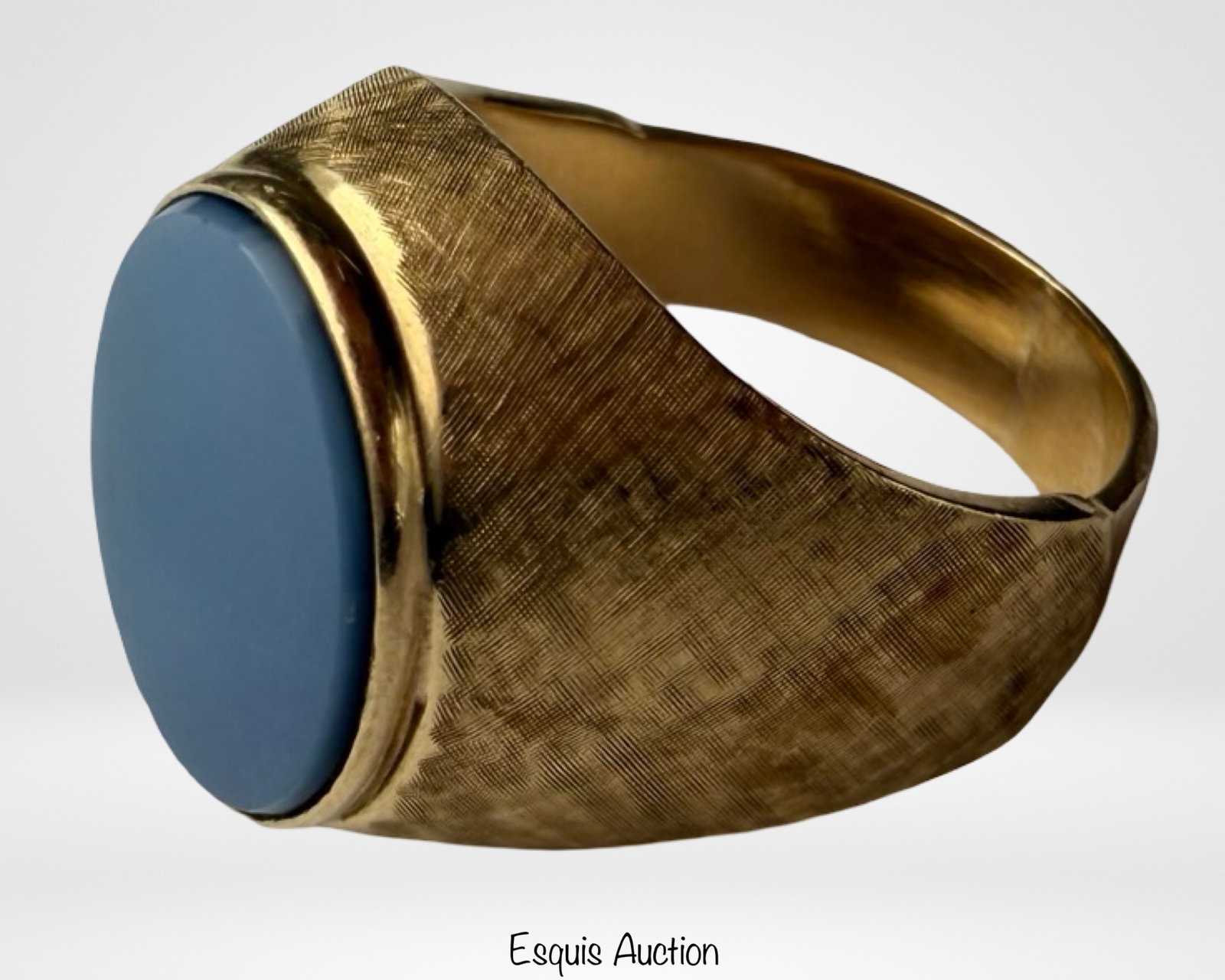 14k Gold Blue Sardonyx Signet Ring: 14k yellow gold signet ring featuring an oval blue sardonyx cabochon stone in a classic bezel setting. The ring has a finely textured crosshatch finish along the shoulders and shank, giving it an eleg