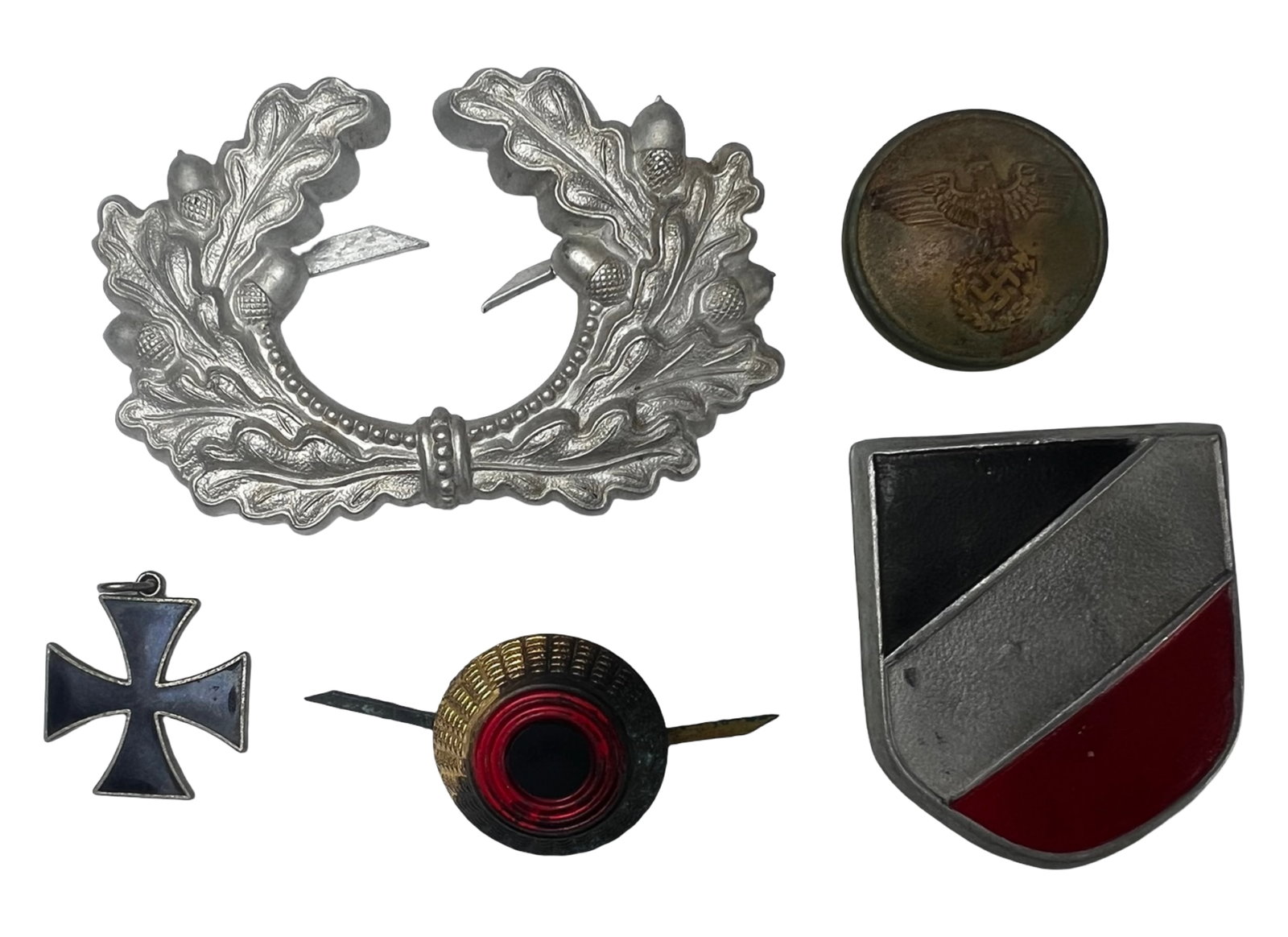 WWII German Army Heer Insignia Group: Assorted group of German military insignia including a WWII-era Army (Heer) officer's visor cap wreath in silvered finish with oak leaf and acorn design; a WWII German Army tropical pith helmet shield