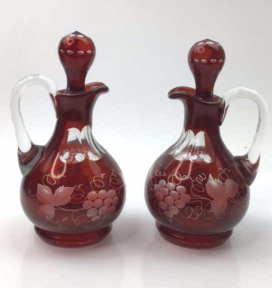 Vintage Cranberry cut to clear oil and vinegar bottles: Vintage cranberry cut to clear oil and vinegar bottles with grapes and leaves cut into them. Very pretty in good overall condition. Both have a very pretty dark cranberry color with good weight and de