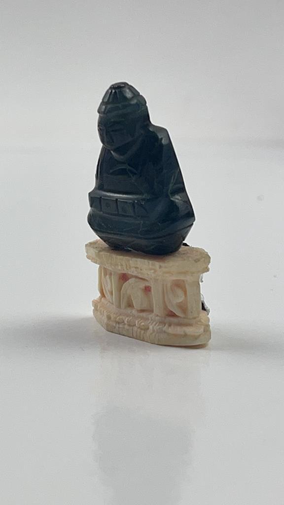Antique Mini Chinese Carved Stone Buddha Bone Base: Antique Miniature Chinese Carved Stone buddha on a bone base. Great to add to any collection. Black stone buddha sits on a pretty white bone base. Good overall condition. Some marking on the back. Mea