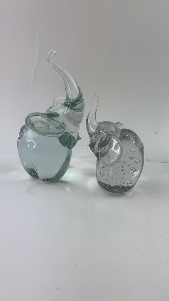 Pair of Clear Murano Glass Elephant Figures: 2 clear glass Murano elephants with trunks up. One elephant has all pretty control bubbles in it. Good Overall condition and weight . Clear elephant has a minor flea bite on the bottom and the figure 
