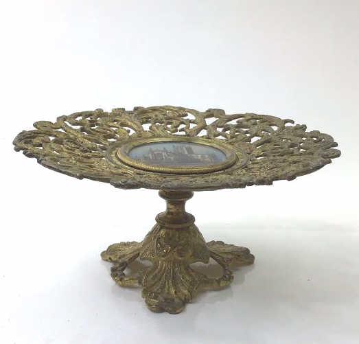 Gilt bronze pedestal dish with etching: Antique guilt bronze pedestal dish tray with an etching in the middle of the Abby church bath. Very pretty good overall condition and weight. About 7"W x3"T $20.00 US Shipping