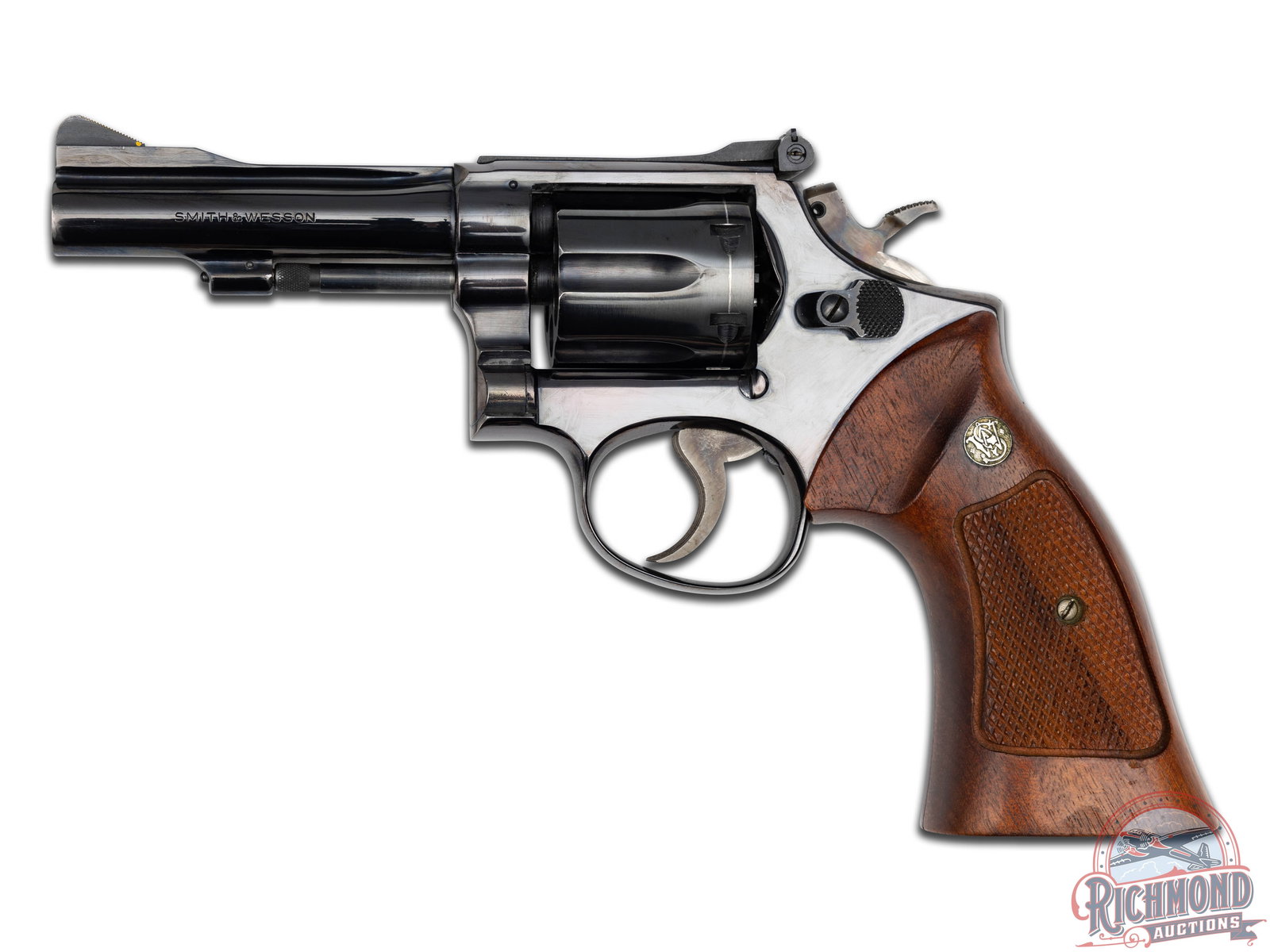 Smith & Wesson Model 15-3 Double Action Revolver: Manufactured in 1969 with standard markings throughout. 4" pinned barrel. Ramped blade front sight with adjustable u-notch rear. Square butt frame. Six shot fluted cylinder. Original blued finish and