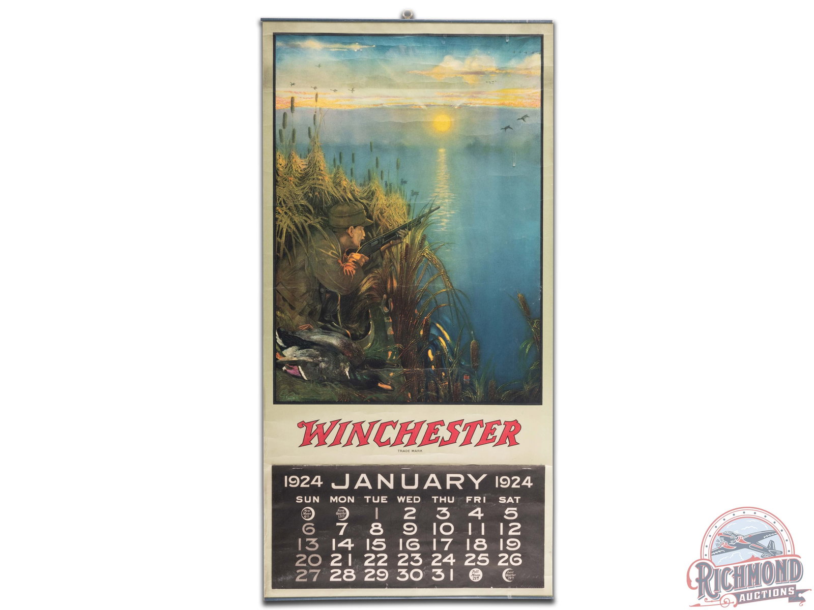 1924 Winchester Paper Calendar: 1924 Winchester calendar. It has good color and shows some areas of wear, minor paper loss, and creases throughout. It has a full 1924 pad. It displays well and has metal bands at the top and bottom. 