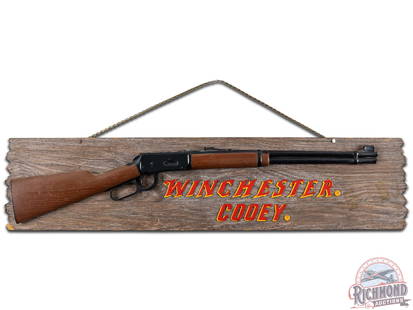 Winchester Cooey Masonite Sign: The sign shows some wear, areas of discoloration, and some spots of damage on the sign and on the rifle. The letters are applied cardboard and the rifle has been repaired where the barrel meets the st