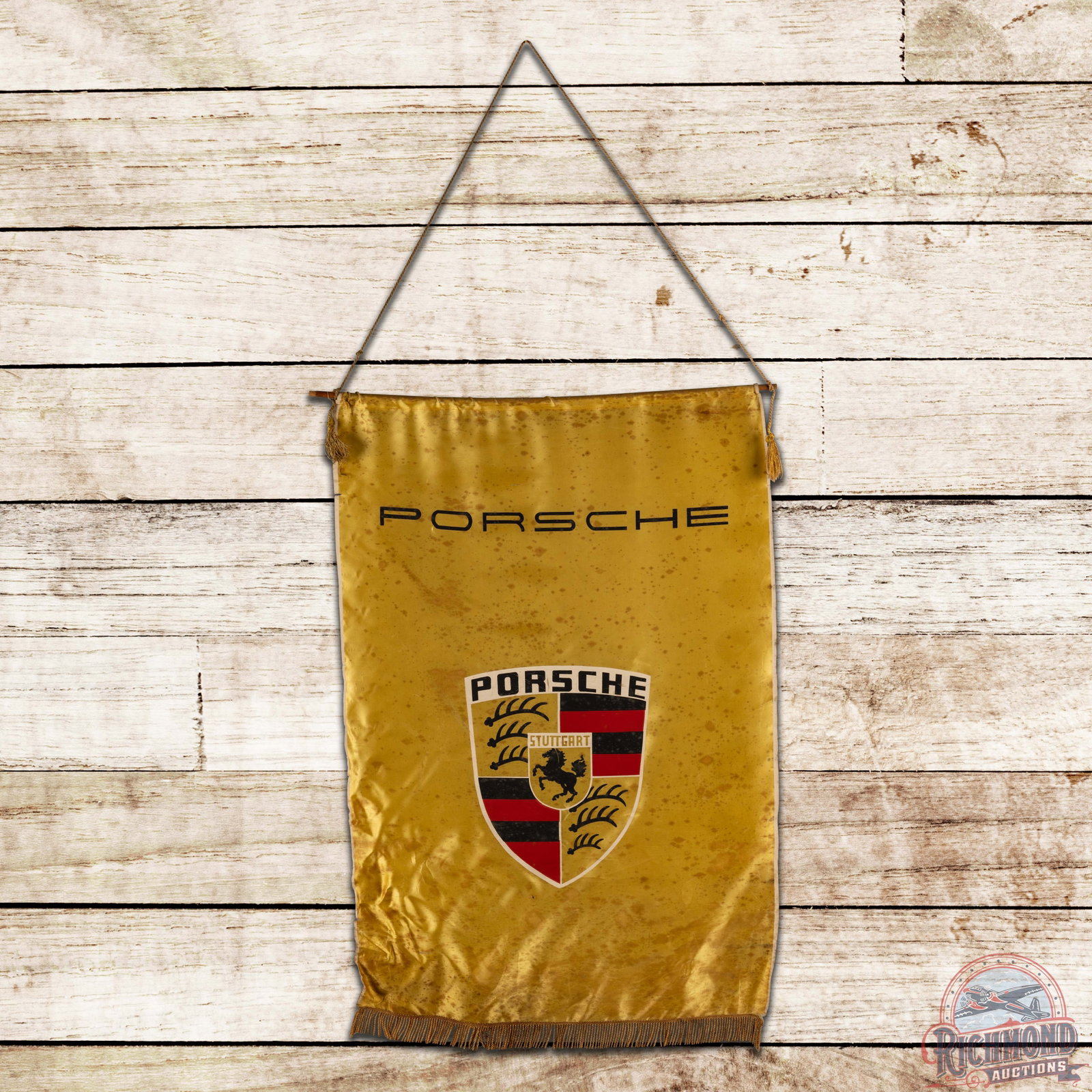 1950s Porsche Stuttgart Dealer Showroom Cloth Advertising Banner: Single sided dealer showroom banner has very good color. The banner is affixed to a wooden hanging rod with tassels. The banner exhibits general spotting throughout with small stress tears and an eras