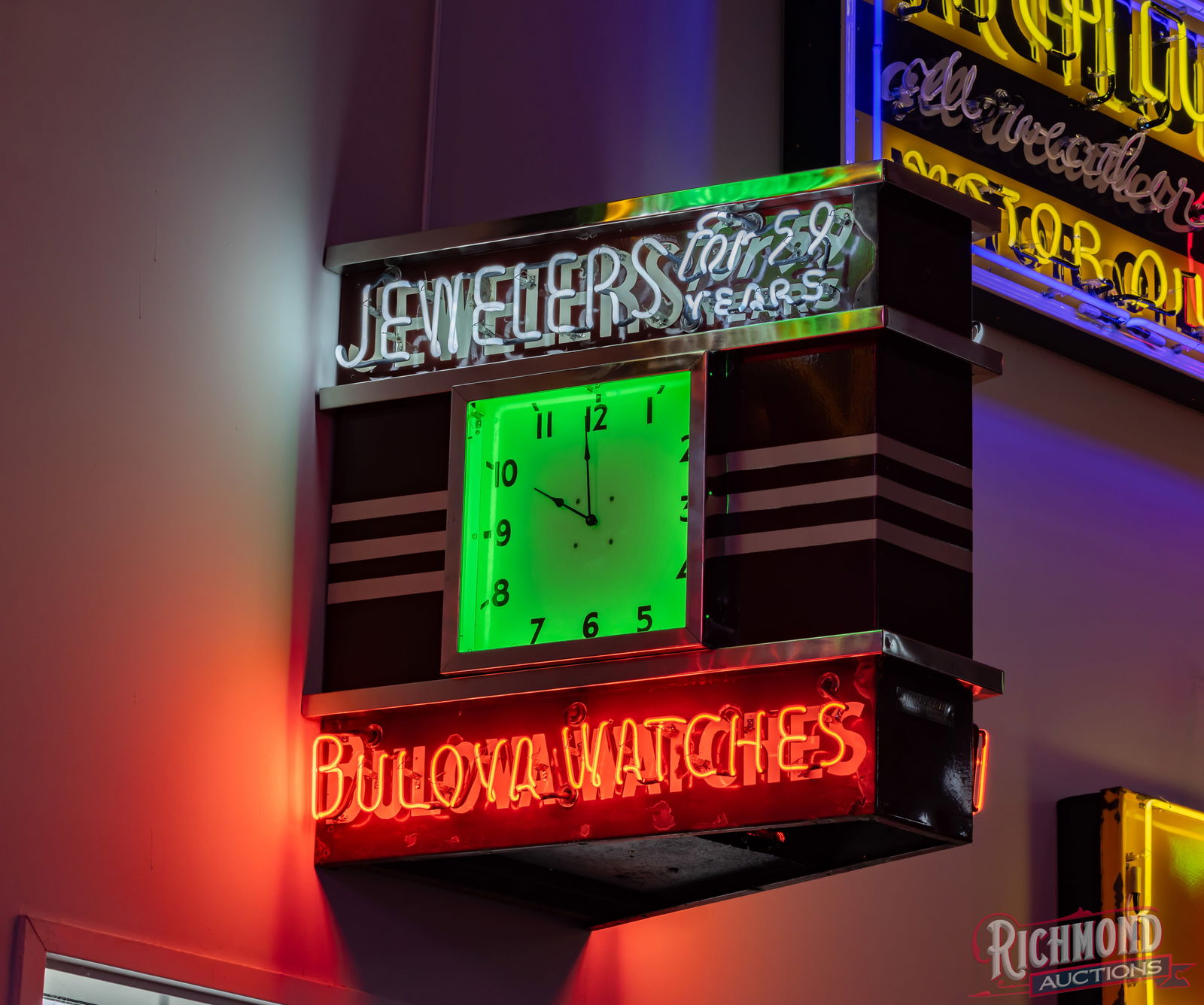 Bulova Watches Jewelers for 50 Years Double Sided Porcelain Neon Sign With Clock: DSP (double sided porcelain) factory neon Bulova sign w/ clock and metal wall mount can. It has excellent color and gloss. The display features a clean clock face with green neon and porcelain surroun