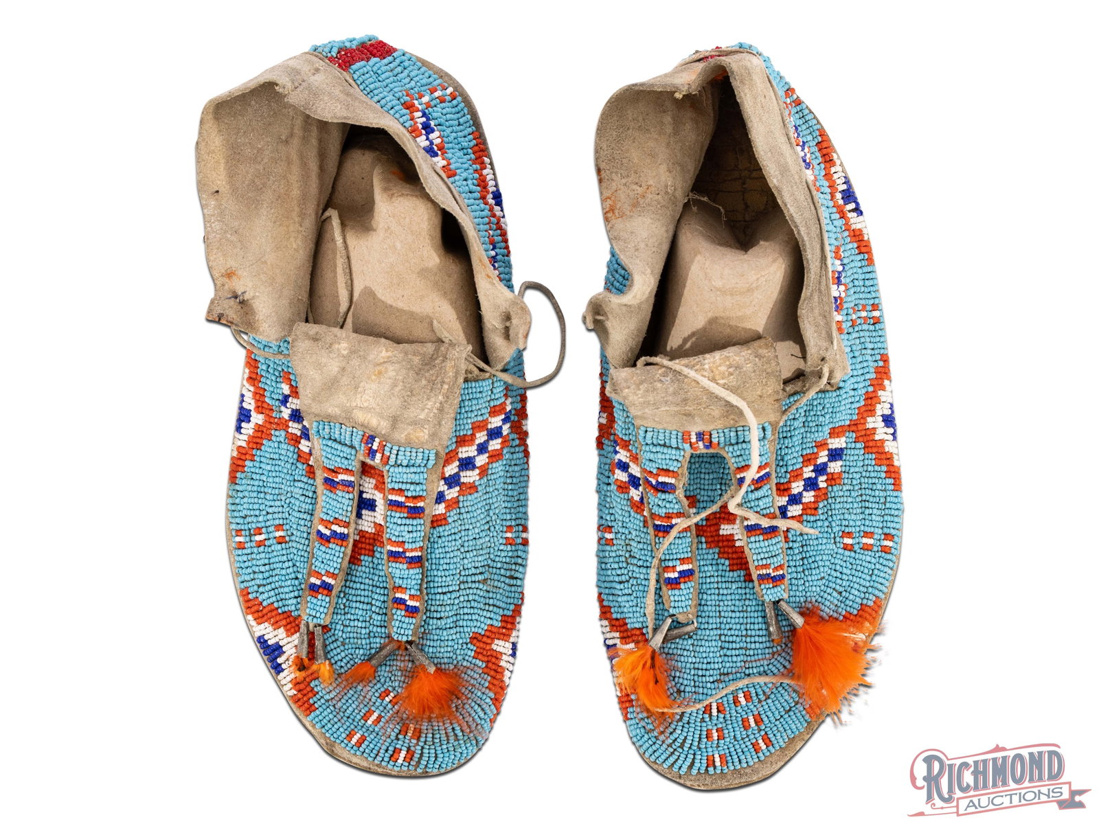 Native American Double Tongued Beaded Moccasins: Moccasins are done with a double tongue coned drop form. Dyed orange feathers protrude from the cone drops and are likely later additions. Approximately 1" in length.