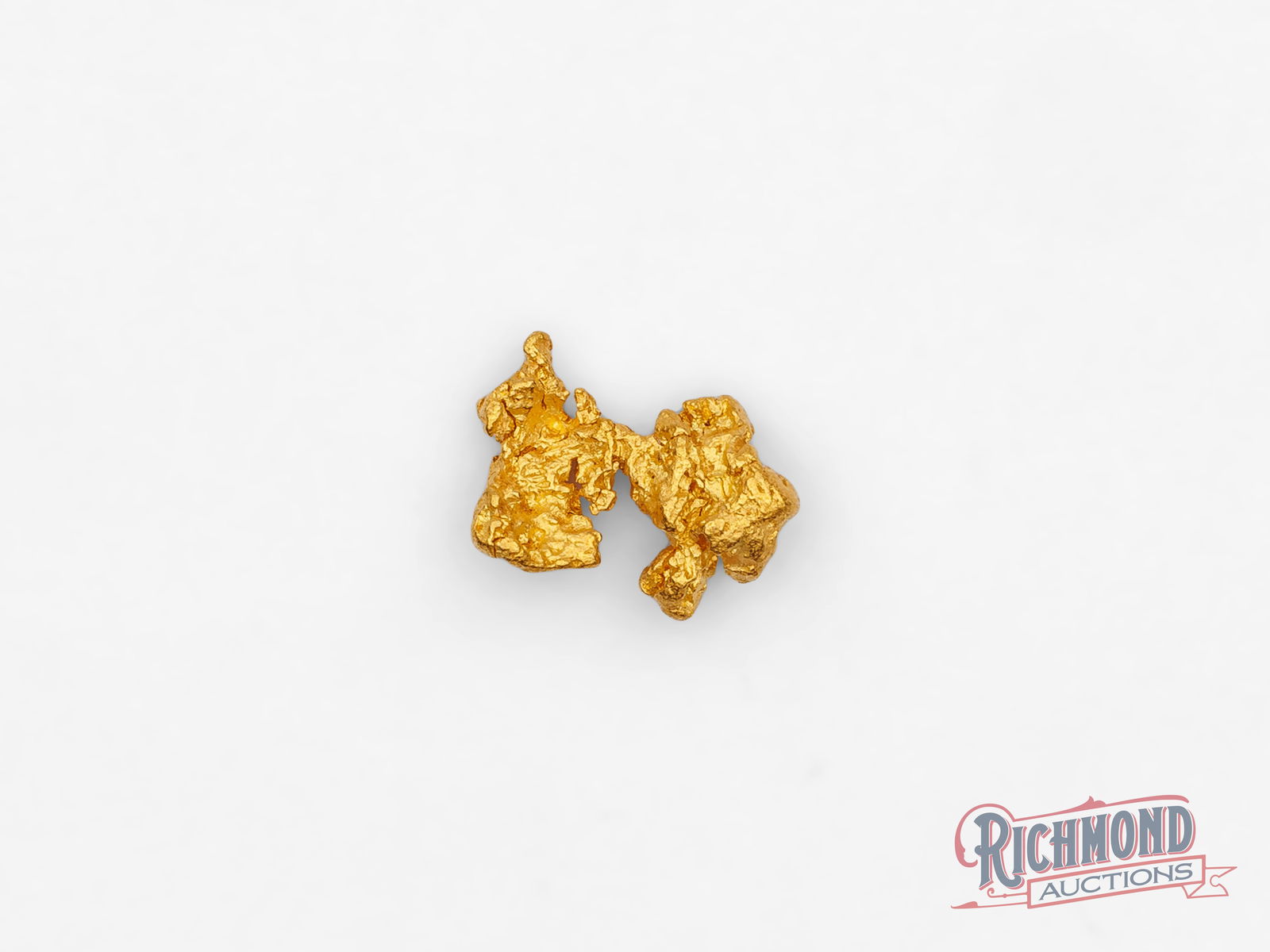 0.9g Natural Bow Tie Gold Nugget: This natural gold nugget has formed into a shape reminiscent of a bow tie, an uncommon and visually distinctive form created entirely by natural processes. Its balanced shape and subtle symmetry give