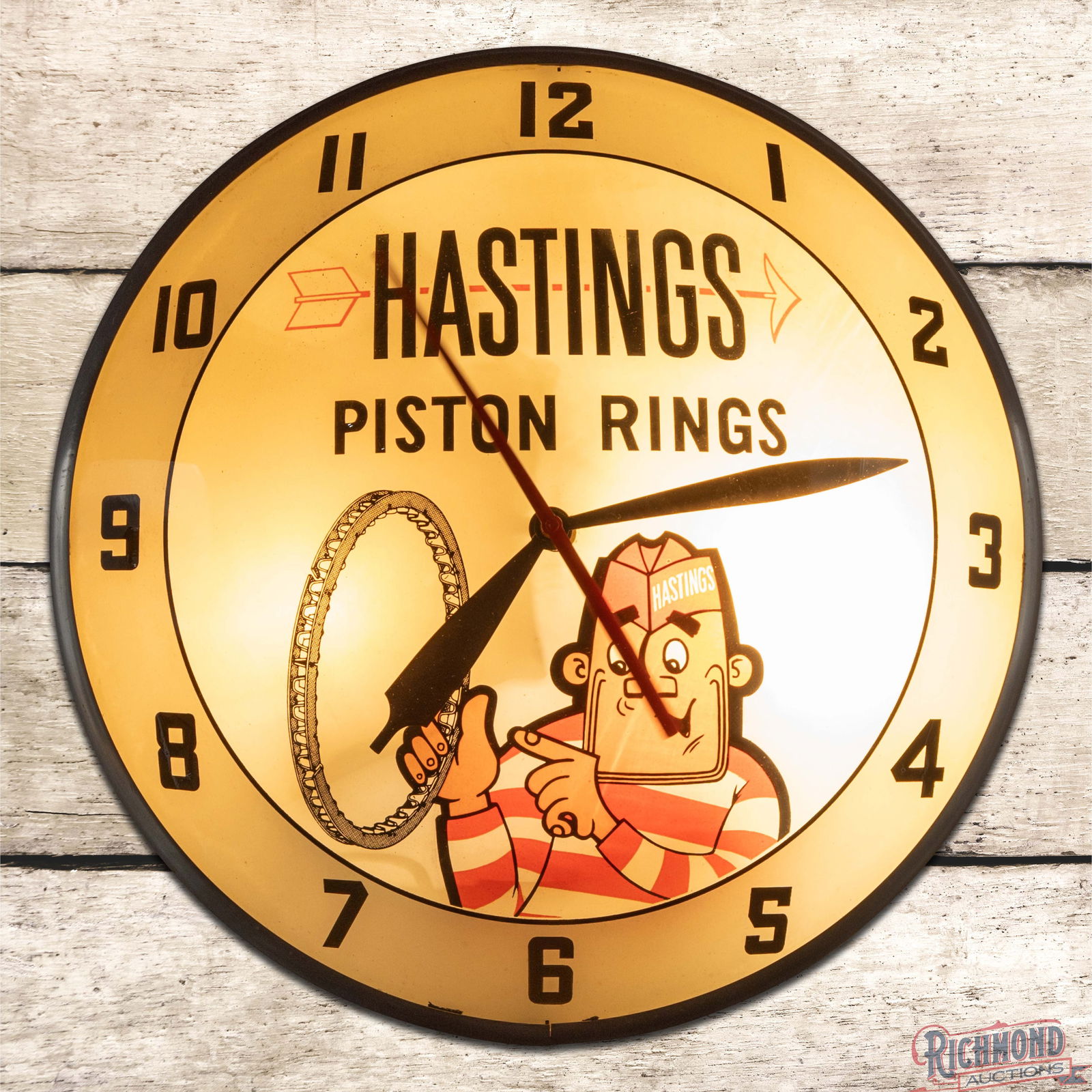 Hastings Piston Rings 15" Lighted Double Bubble Advertising Clock w/ Mascot: Lighted double bubble clock runs and lights as it should. The clock has wonderful graphics with vibrant colors throughout. The inner face is very clean overall with a small area of discoloration in