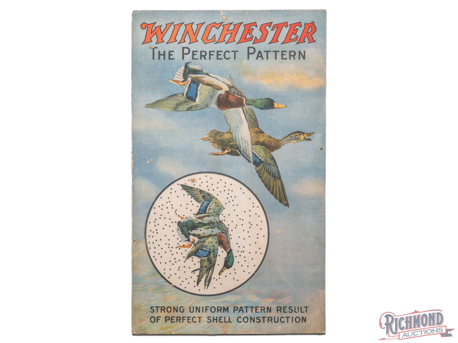 Winchester The Perfect Pattern Cardboard Advertising Display Sign: Single sided cardboard sign has good color. The field has surface imperfections with small non-factory holes. The perimeter has minor soiling with non-factory holes and edge wear. It has been shrink w