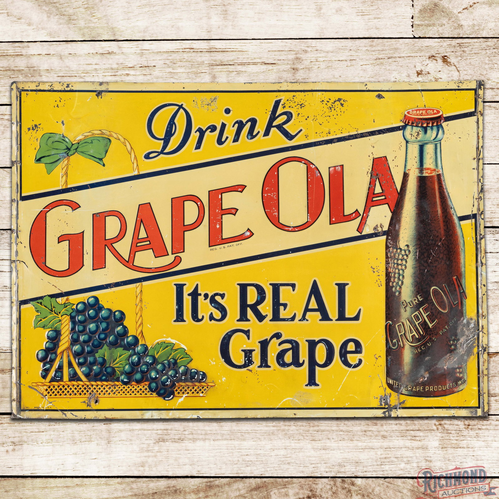 Drink Grapeola It's Real Grapefruit Emb. Single Sided Tin Tacker Sign w/ Bottle & Grapes: SST (single sided tin) embossed tacker sign has good color and shine. The display has general wear throughout with non-factory holes, bends paint loss and blistering paint. The perimeter has additiona