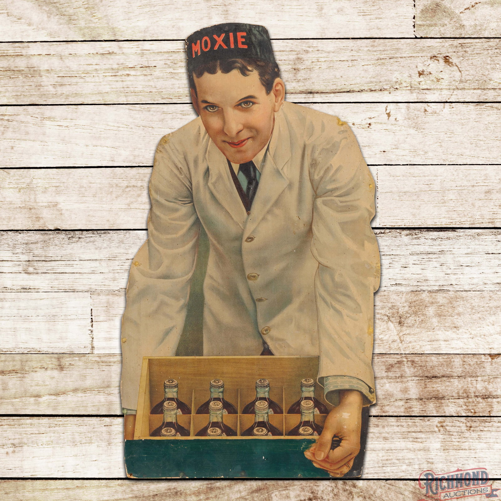 Early Moxie Cardboard Advertising Display Sign w/ Soda Jerk & Bottles: Single sided die cut cardboard advertising display sign has good color. The sign has slight toning throughout with areas of surface spotting. The field and perimeter have added holes of which all but 