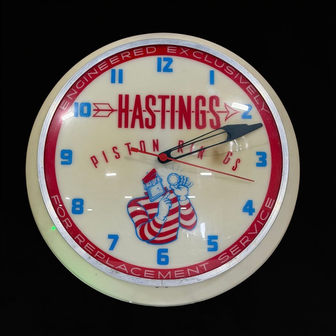 Hastings Piston Rings: Face is cracked. I believe one of the bulbs shorted out in the past and they removed it, so only 1 light. You can see burn mark after the N in rings. 16" H x 5" W. All items are eligible for free deli