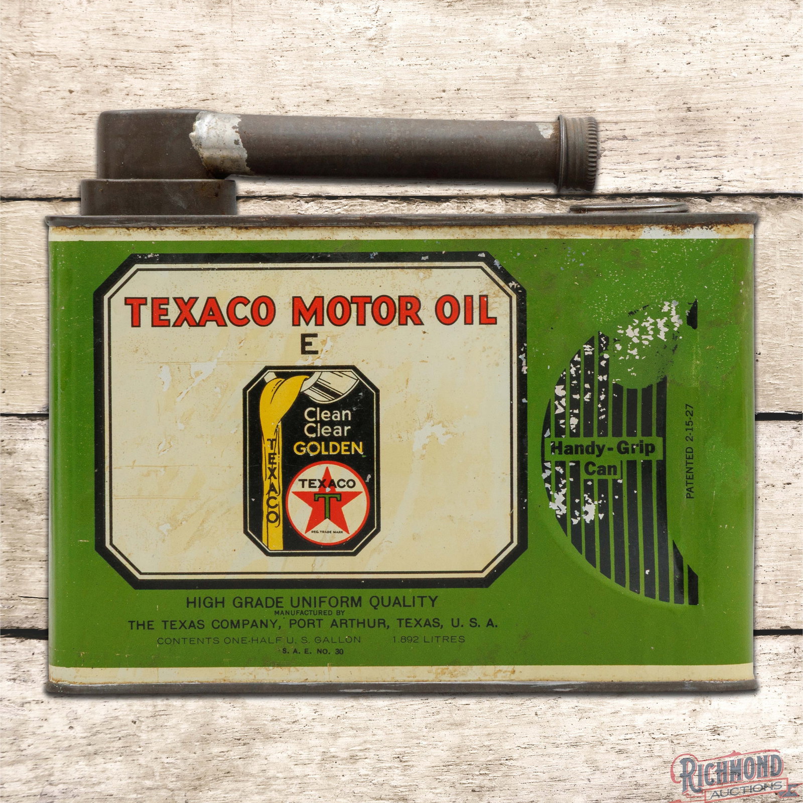 Texaco Motor Oil "E" Empty Metal Half Gallon Can: Empty metal half-gallon handy grip can with the original cap and spout has very good color and shine. The display has light wear, fine scratches, paint chips and a few small indentations. The reverse 