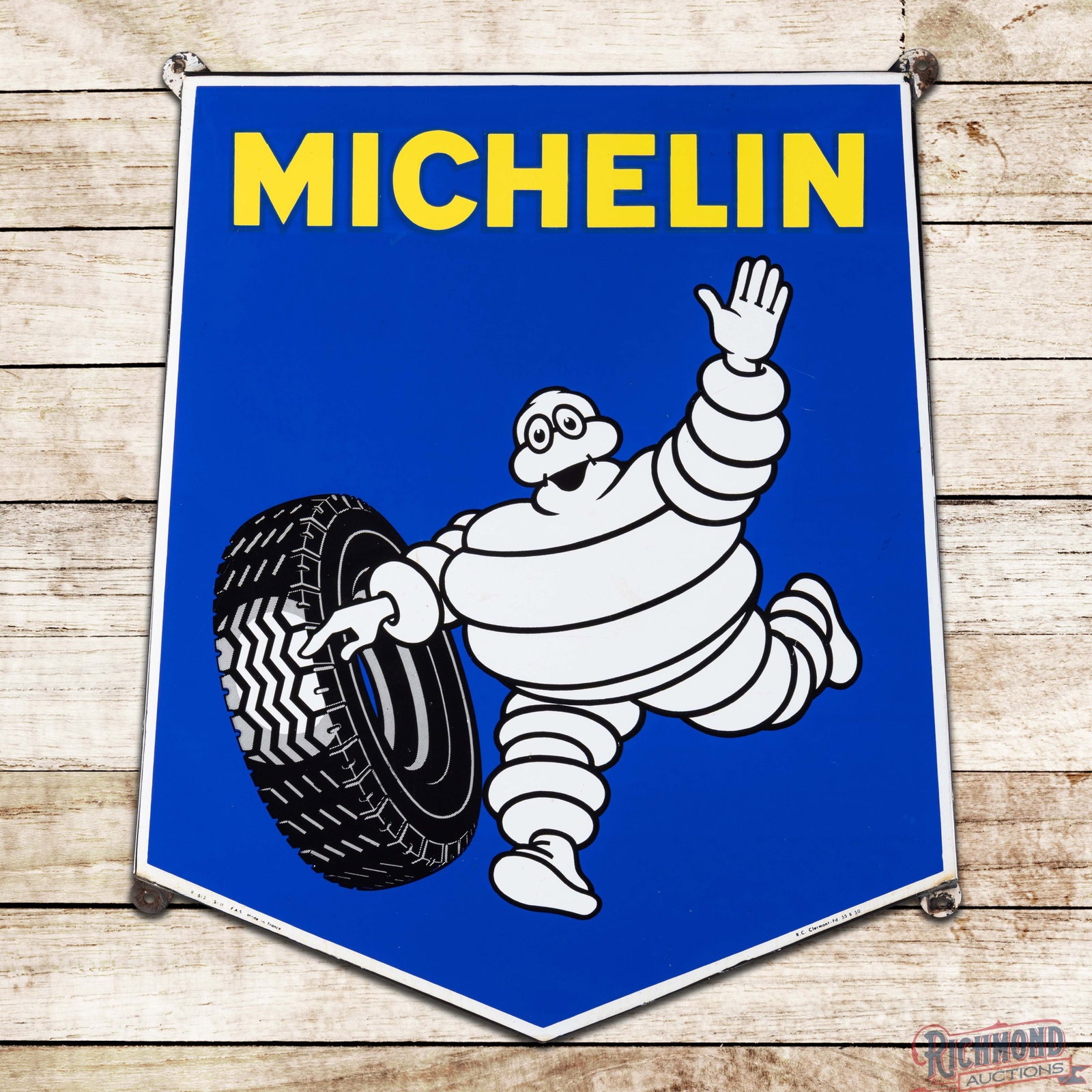Michelin Tires Die Cut SSP Sign w/ Bibendum: SSP die cut, rolled-edge sign has excellent color and gloss. The field is very clean overall with light wear and small areas of discoloration. The perimeter has small chips along the outer edges. Mark