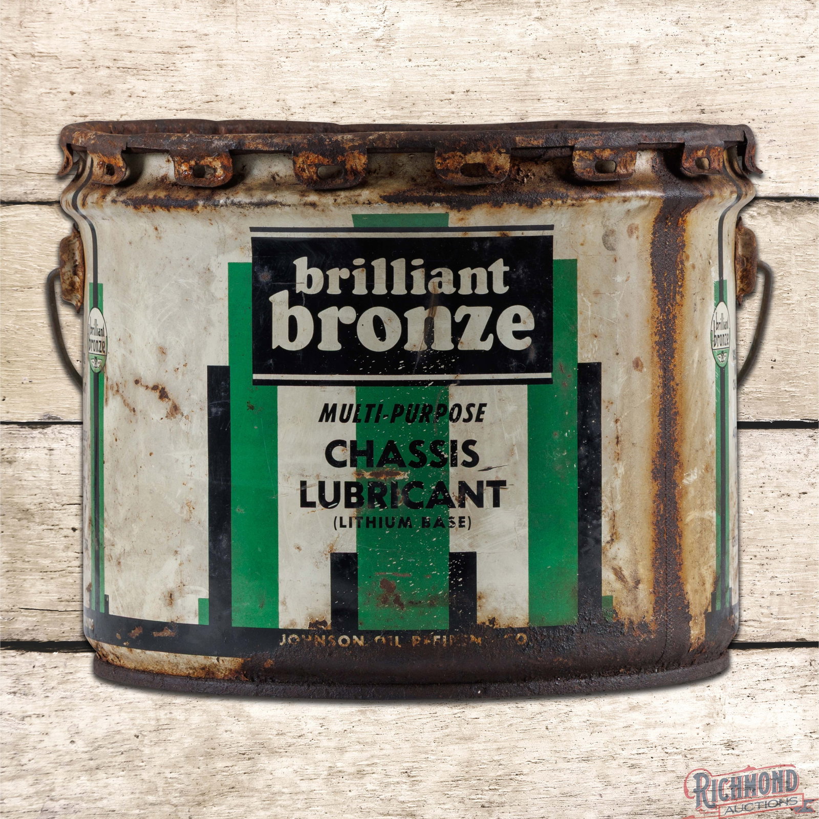 Johnson Brilliant Bronze Chassis Lubricant 25 Pound Metal Grease Can: 25 pound metal grease can with the original handle and lid has good color. The display has grease residue with areas of oxidation and surface wear that is more prominent along the perimeter. The rever