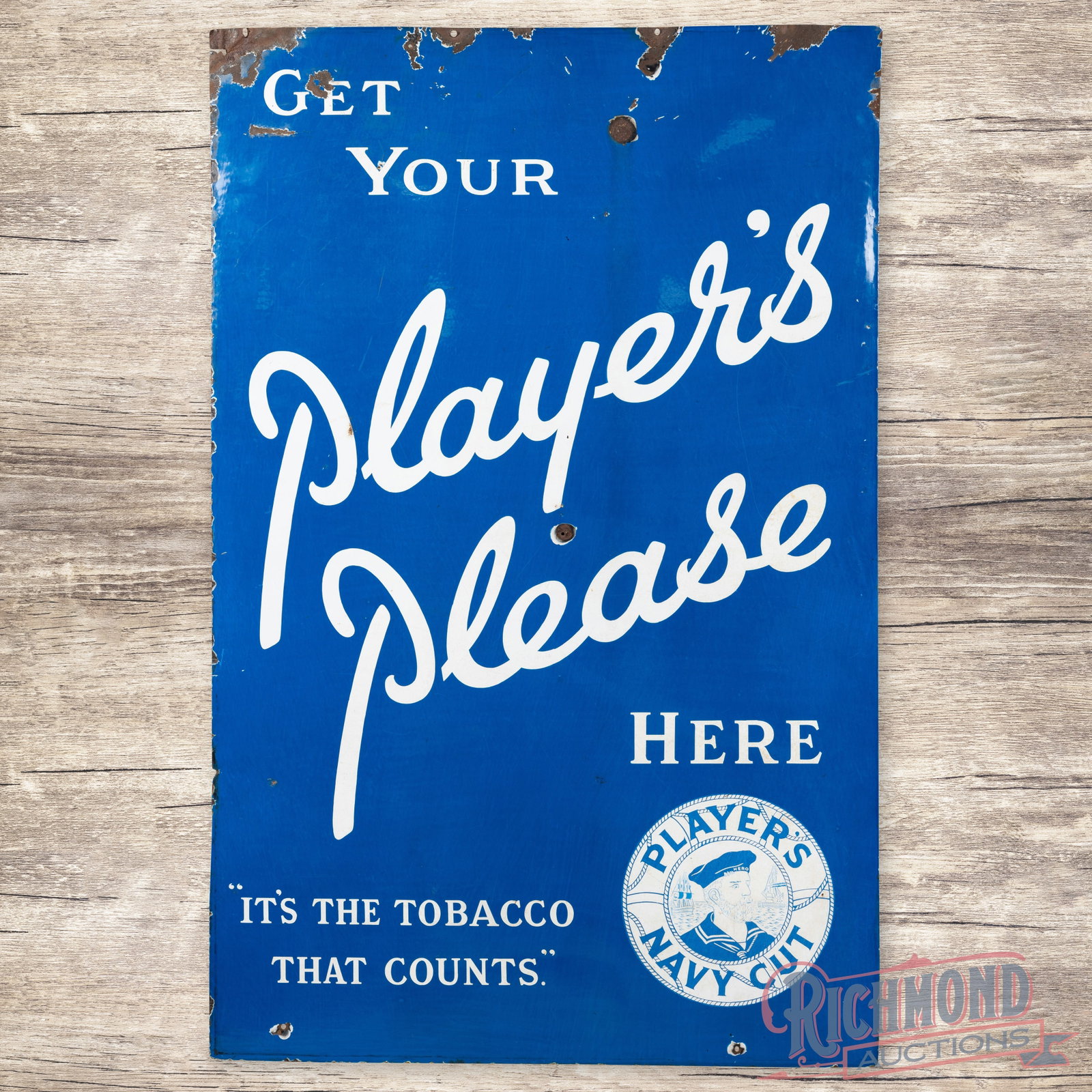 Get Your Player's Please Tobacco Here 5' Single Sided Porcelain Sign w/ Logo: SSP (single sided porcelain) sign has very good color and gloss. The display has surface wear with slight discoloration in the lettering, chips, and a non-factory hole below the "Y" in Player's. The p