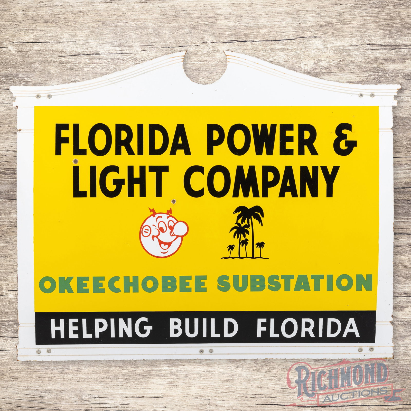 Florida Power & Light Company Okeechobee Substation w/ Reddy Kilowatt & Palm Trees: SSP (single sided porcelain) die cut sign has very good color and gloss. The display has light wear with two small chips in the field and bruises in the upper right outer field. The perimeter has slig