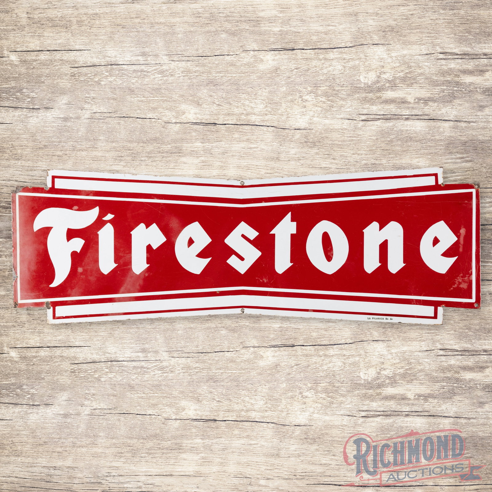 35" Single Sided Porcelain Die Cut Firestone Sign: SSP (single sided porcelain) Firestone Sign with excellent color and gloss. Exhibits with surface wear, some areas of discoloration and edge loss on the left. Marked La Pilarica Bg. Ag. 12" H X 35.25"