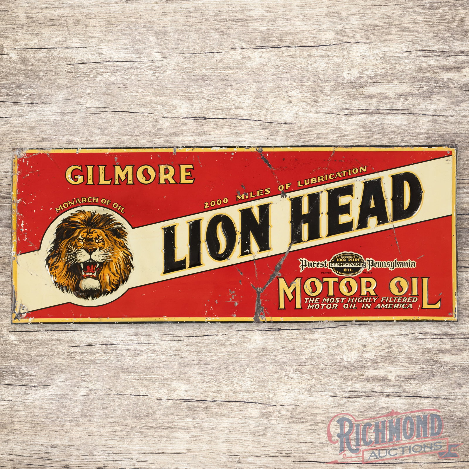 Gilmore Lion Head Motor Oil Emb. Single Sided Tin Sign: SST (single sided tin) embossed self-framed sign has good color and shine. The display has paint chips with wear, bends, and non-factory holes in the lower field. The perimeter has edge wear with bend