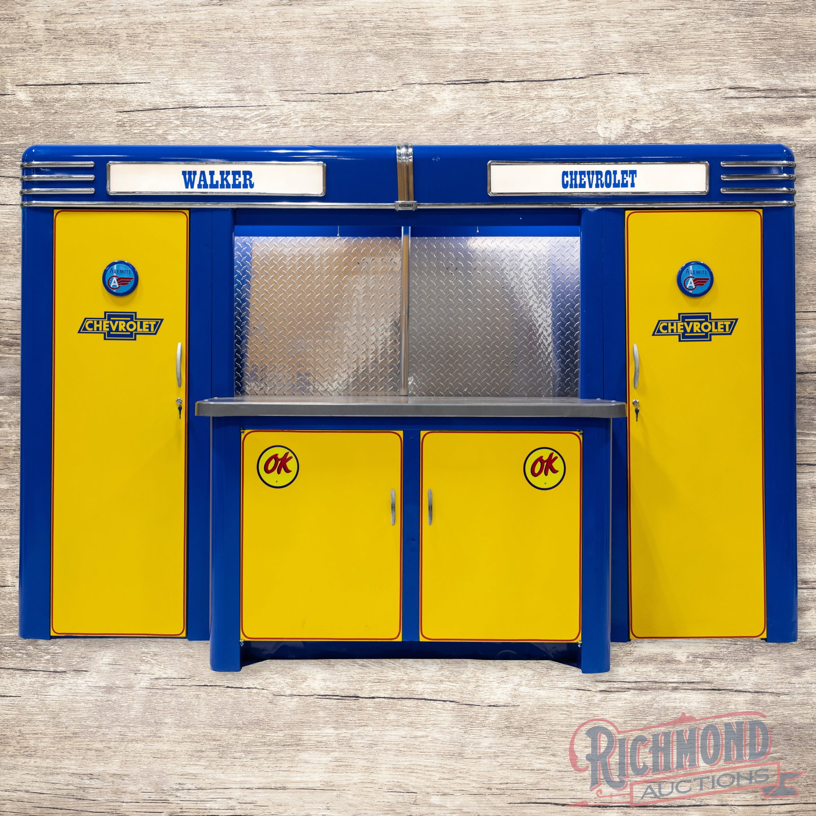 Alemite OK Chevrolet Service Station Cabinet Professionally Restored: Alemite service station cabinet has been professionally restored. The cabinet features vibrant yellow and blue paint with high gloss. The paint has areas of light wear, minor imperfections, and a smal