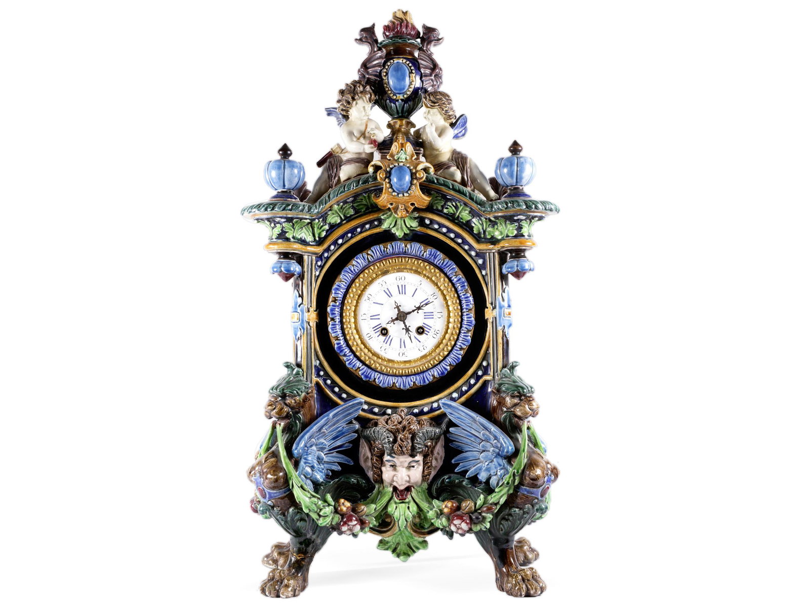 Magnificence mantel clock around 1880: Magnificence mantel clock around 1880 German/Mettlach? Around 1880/90 Faience, figural and ornamental shaped and colorfully painted Height 61 cm, width 33 cm, depth 20 cm Three legs and the vase crown