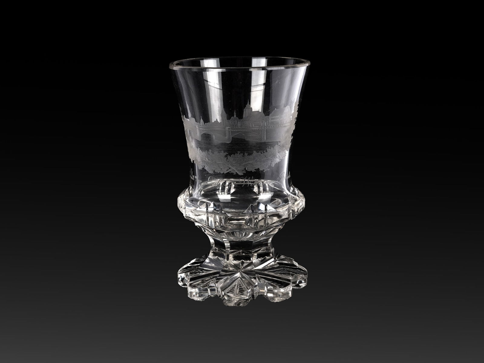 FOOTED CUP WITH A VIEW OF THE CITY OF ULM AND THE LUDWIG-WILHELMS-BRUECKE: Footed cup with a view of the city of Ulm and the Ludwig-Wilhelms-BrueckeEngraving by J. E. Lindenmeyer, UlmBohemiaAround 1835Colorless glassHeight 14.8 cm