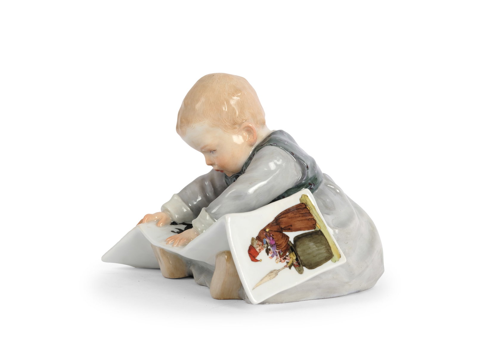 HENTSCHEL CHILD WITH PICTURE BOOK, MEISSEN PORCELAIN: Hentschel child with picture bookMeissen porcelainDesigned by Konrad HentschelCirca 1905Polychrome porcelain12 x 12 cmMarked on the base