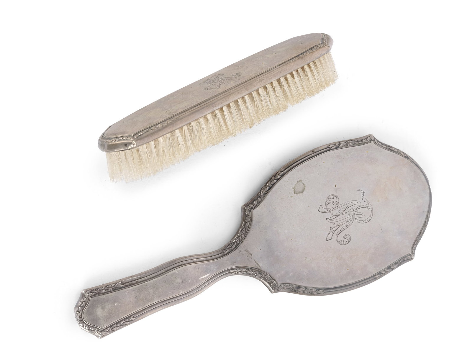 TOILETRY SET: HAND MIRROR and BRUSH, CIRCA 1910: Toiletry set: Hand mirror and brushCirca 1910Monogram MRHallmarked silver (800)Mirror length 27.5 cmTotal weight 266 gDents in the silver