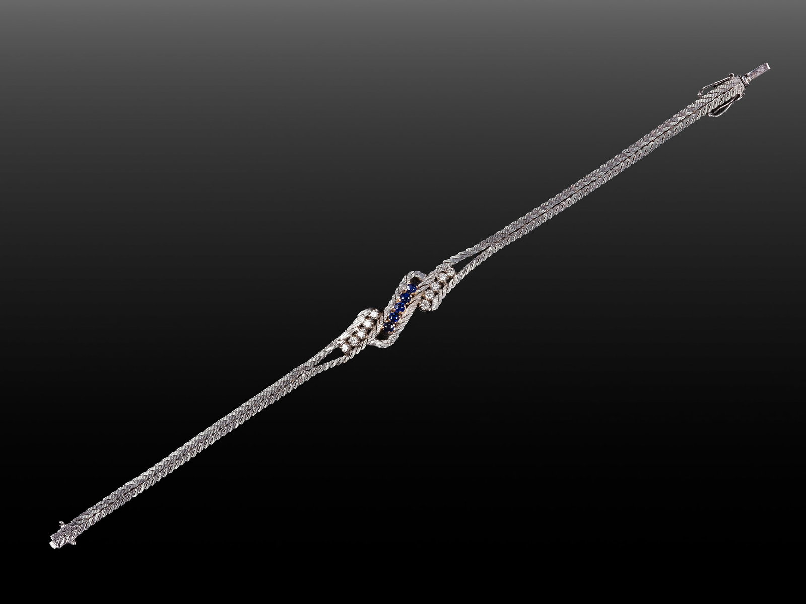 BRACELET, 14 KT WHITE GOLD: Bracelet14 kt white goldSet with 10 brilliant-cut diamonds, approx. 0.05 ct each, and 5 sapphiresLength 18.5 cmWeight 13.5 g