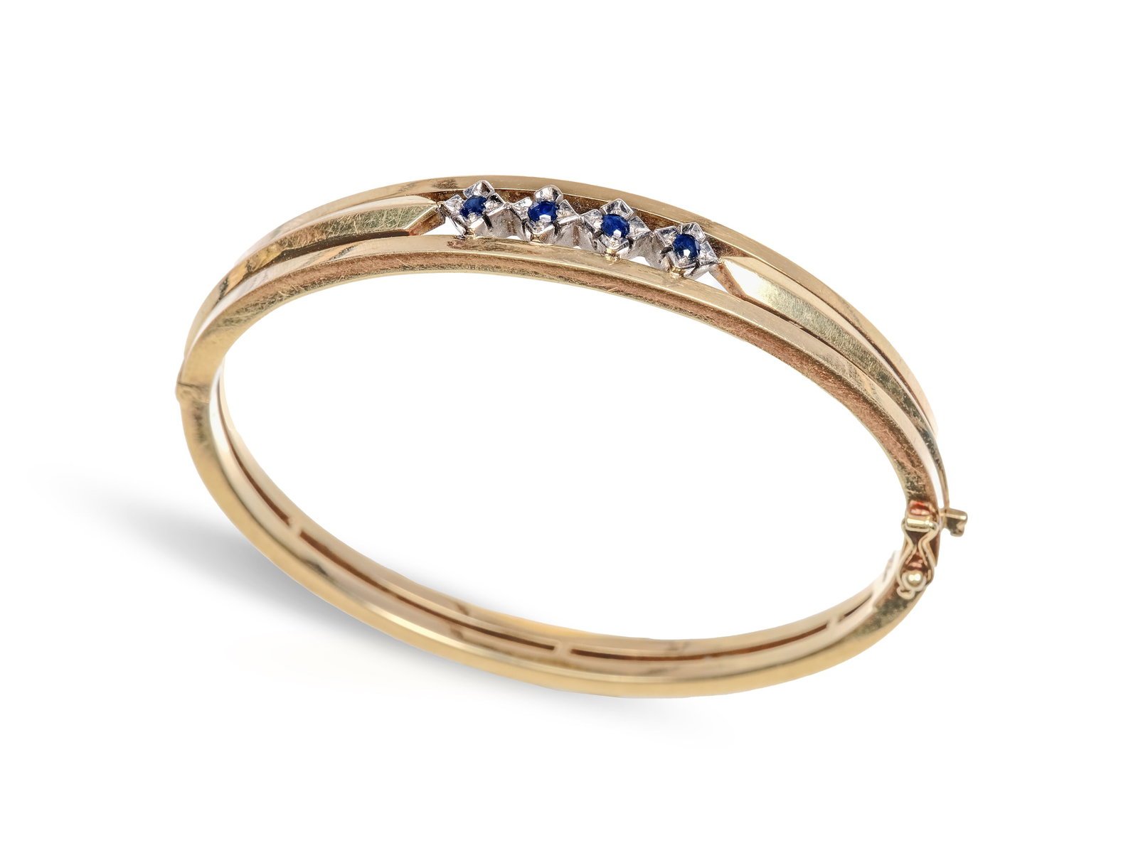 BANGLE, 14 KT YELLOW GOLD: Bangle14 kt yellow goldSet with four small sapphires totaling approx. 0.2 ct 6 x 5.4 cm, width 0.9 cmWeight 22.8 g