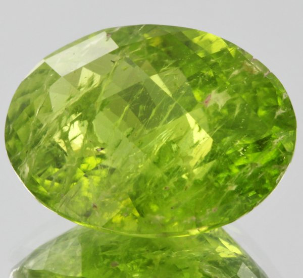 10.51ct Parrot Green Peridot Oval Cut: Excellent untreated grade 6 of 10 specimen; estimated Gem Guide wholesale $120, estimated retail $350; Pakistan origin