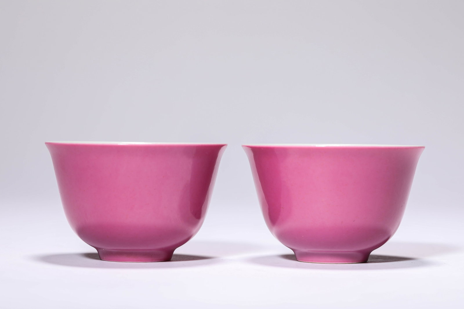 A PAIR OF ROUGE-GROUND SMALL CUPS: A PAIR OF ROUGE-GROUND SMALL CUPS A PAIR OF ROUGE-GROUND SMALL CUPS Description: Dimensions: Width: 7.3 cm x Height: 5 cm. All measurements are approximate.
