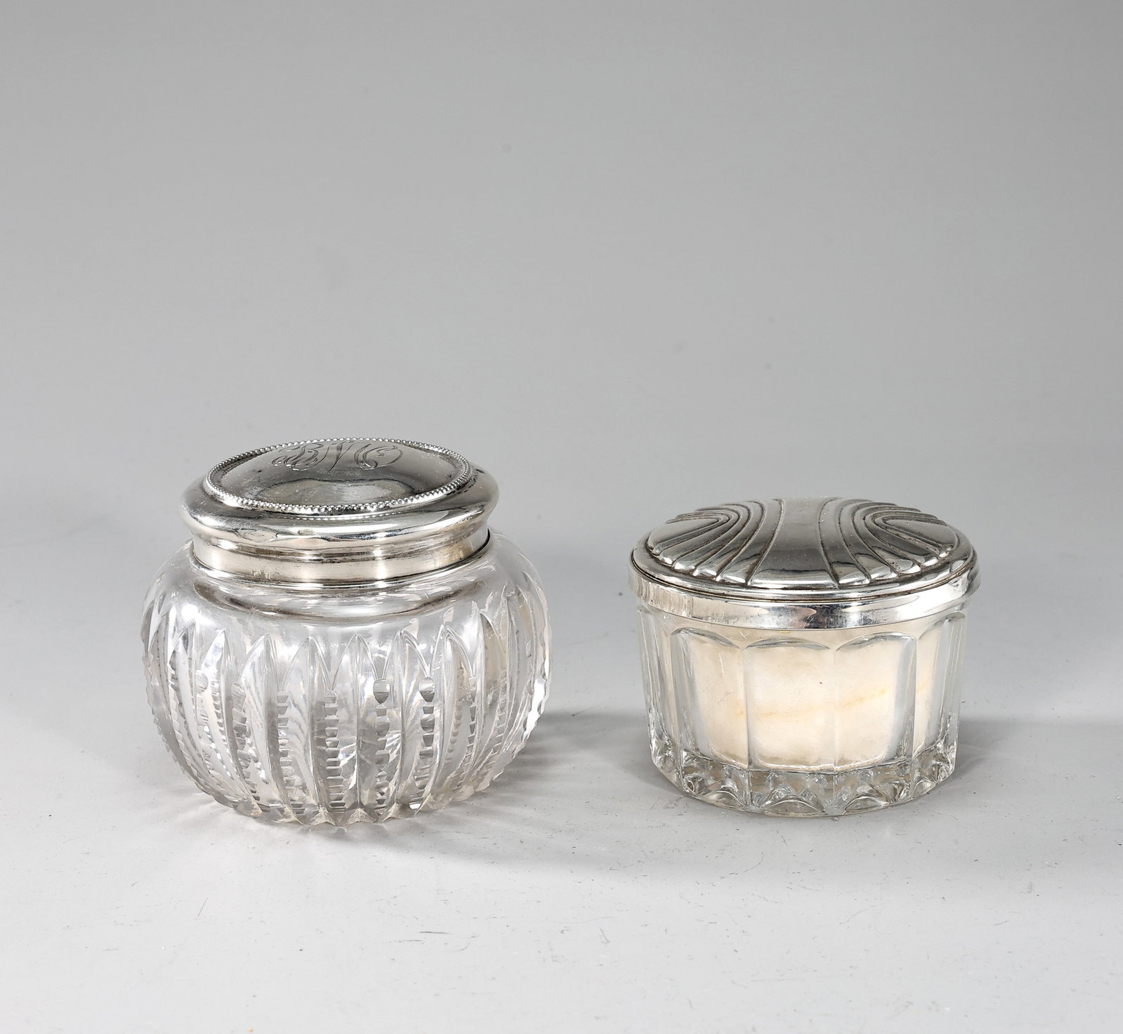 Vintage Cut Glass Vanity Jar With Sterling Silver Lids Set Of 2: Vintage Cut Glass Vanity Jar With Sterling Silver Lids Set Of 2 (9 x 8 cm,8 x 5.5 cm) Condition: there is dents on the lid of Jar, and mirror broken on powder silve jar, sold as found,