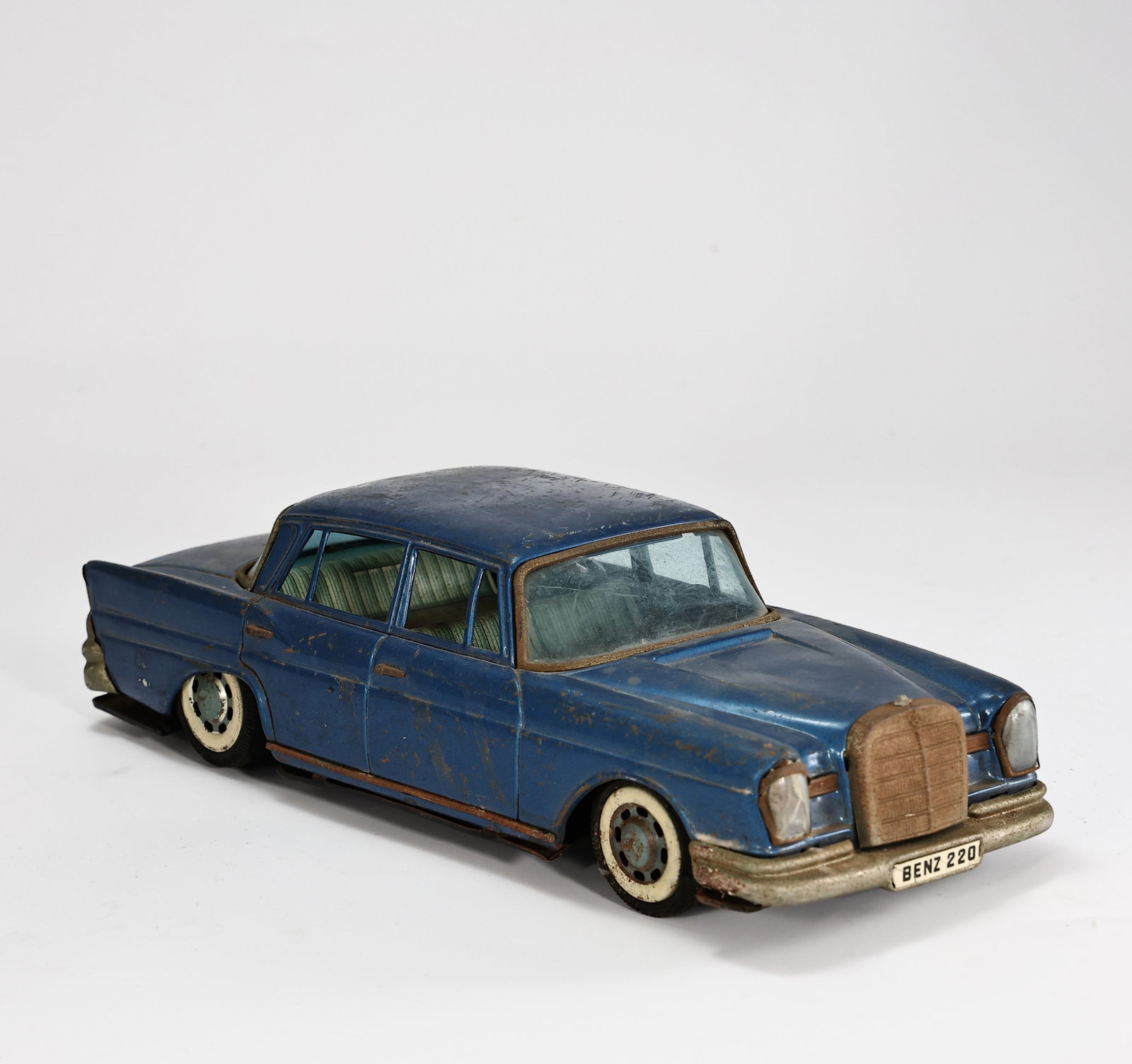 1960s Mercedes Benz 220 Sedan Tin Car: 1960s Mercedes Benz 220 Sedan Tin Car (26 x 9 x 7 cm) This is a vintage Dinky Toys 186 Mercedes-Benz 220SE die-cast model car from the 1960s.The model features a blue body, a cream interior, and histo