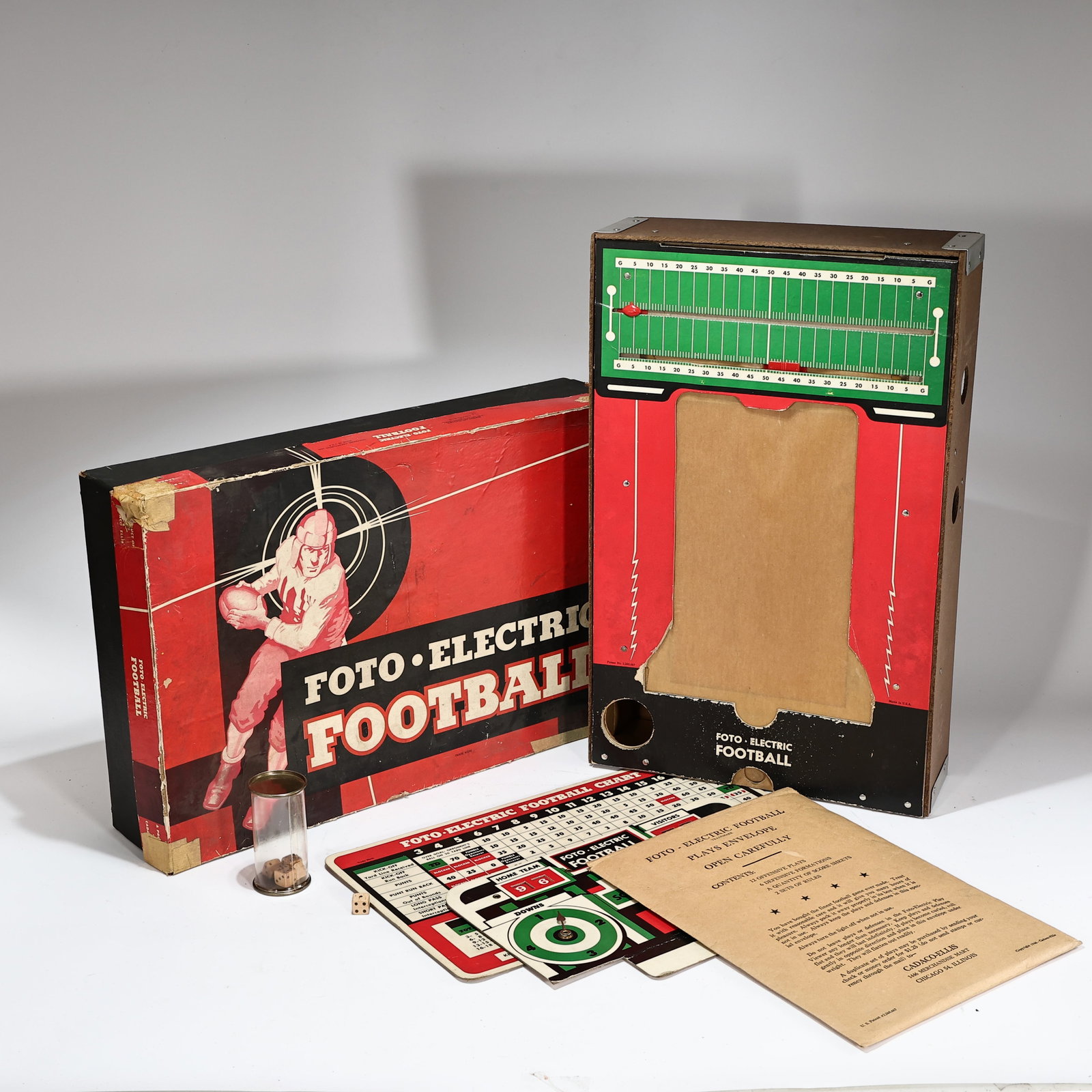 1950s Cadco Foto Electric Football Game: 1950s Cadco Foto Electric Football Game (Box: 49 x 31 x 10 cm) Vintage 1950s Foto-Electric Football game produced by Cadaco-Ellis, featuring a red and black cardboard box with illustration art.The gam