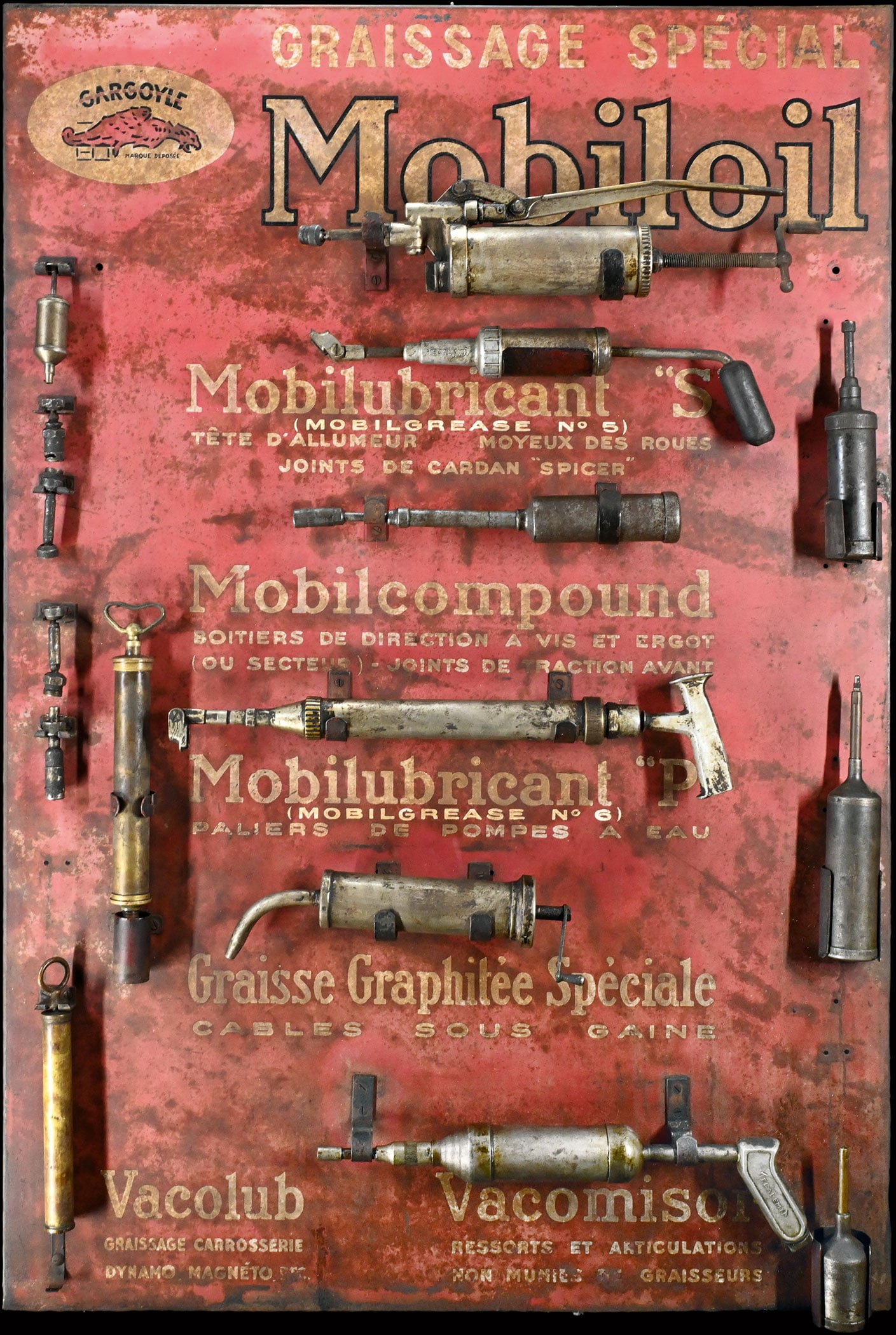 GARGOYLE MOBILOIL | 50" TIN SIGN: Tin sign with attached holders for various grease guns and lubricants, still equipped with the original items, 1930s, impressive large format, 86 x 128 cm, the appropriate Mobiloil lubricant grades to
