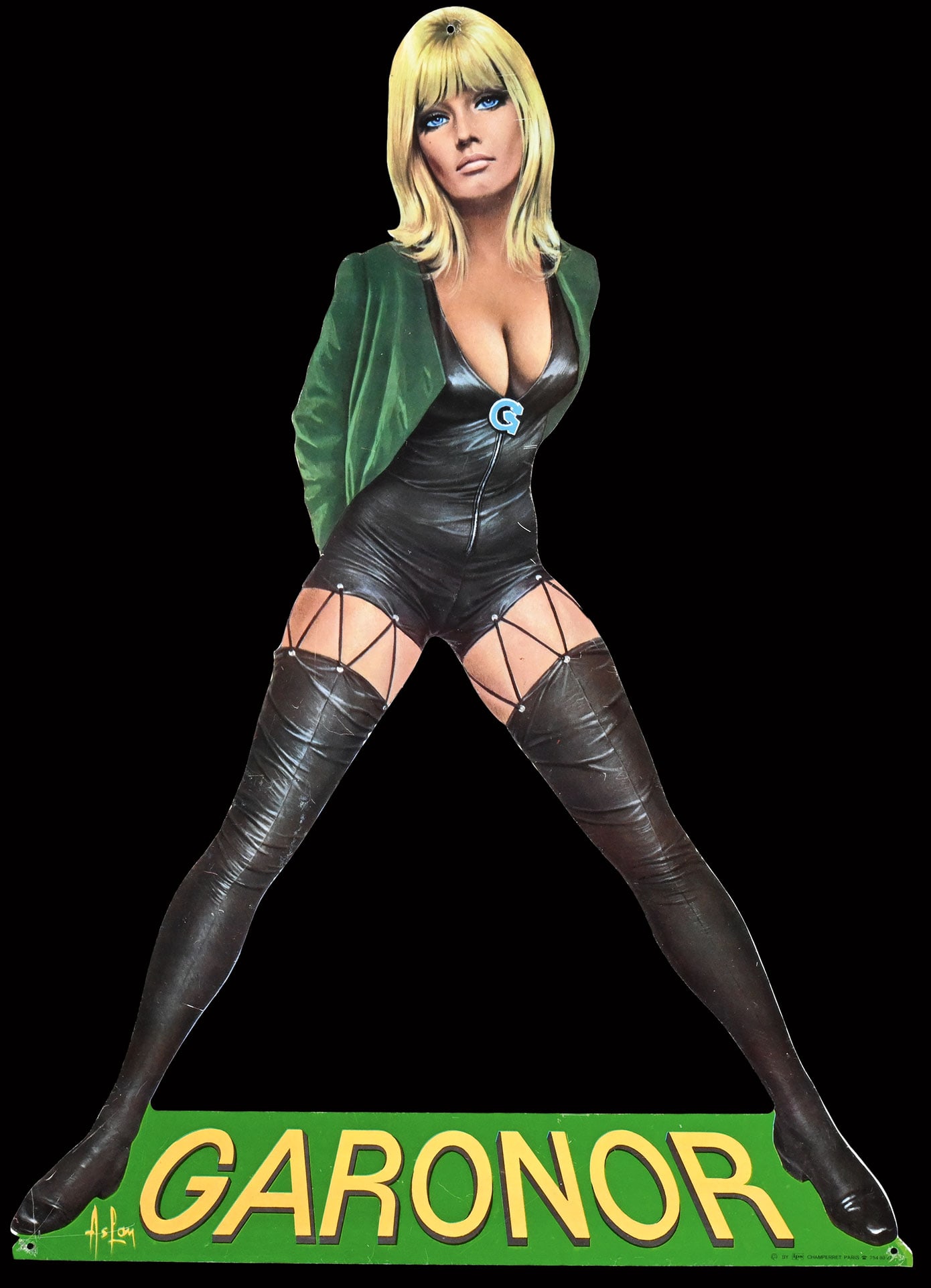 GARONOR | 19" PIN UP: Tin, F around 1970, 36 x 48 cm, IPS Champerret Paris, signed: Aslan; dressed provocatively in leather, the 'Garonor Girl' gazes at the viewer - considered by many enthusiasts to be the most iconic pin