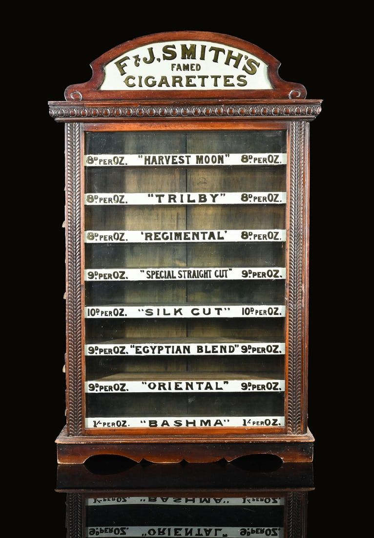 F & J. SMITH CIGARETTES CABINET DISPLAY | SALES CABINETT | (1-2): Ancient sales cabinet, wood with glass panels, reverse glass prints, 8 compartments with side-opening drawers, ENG around 1900, 63 x 15 cm, H 100 cm, beautiful original condition |*Bulky-item shipping
