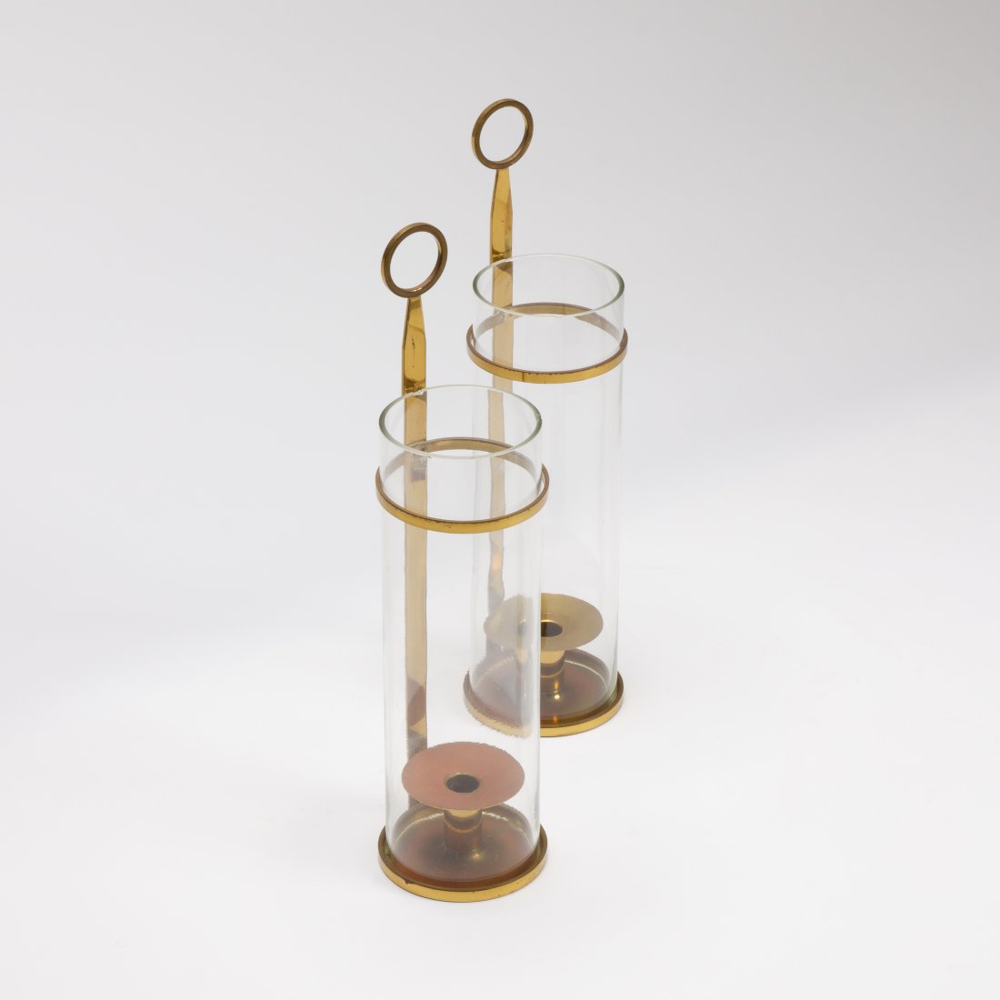 Tommi Parzinger, Hurricane Lamps: USA, 1950s brass, glass 19" x 4.75" Pair of brass hurricane lamps by Tommi Parzinger for Dorlyn Silversmiths with glass column inserts; marked under base. Provenance: Private collection, NYC key: mid 