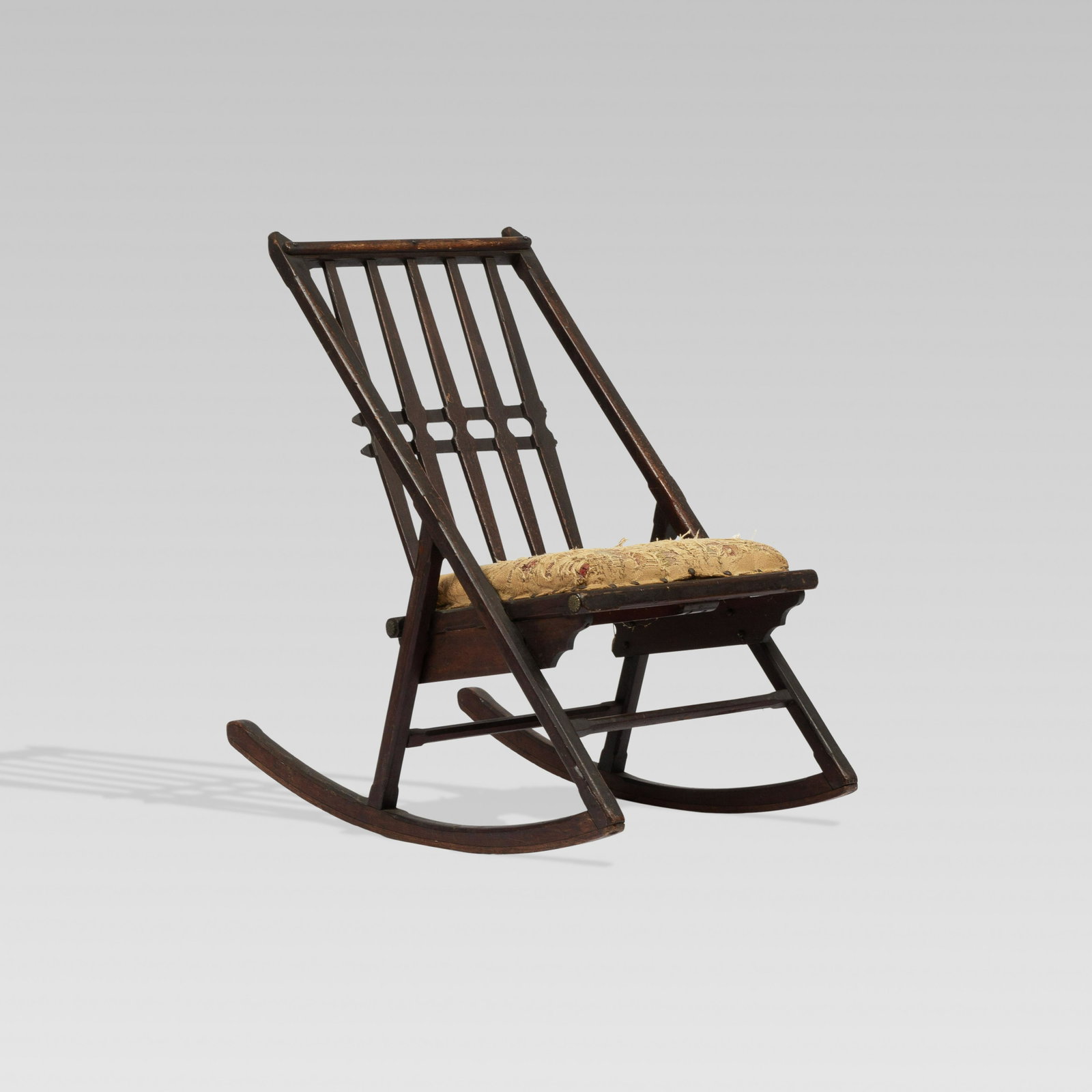 Aesthetic Movement, Rocking Chair: USA, c. 1880 wood, brass, upholstery, screws 32 1/8” x 18” x 30 1/2” x 16” seat Aesthetic Movement rocking chair with simple geometric backrest, scrolled seat frame and brass a