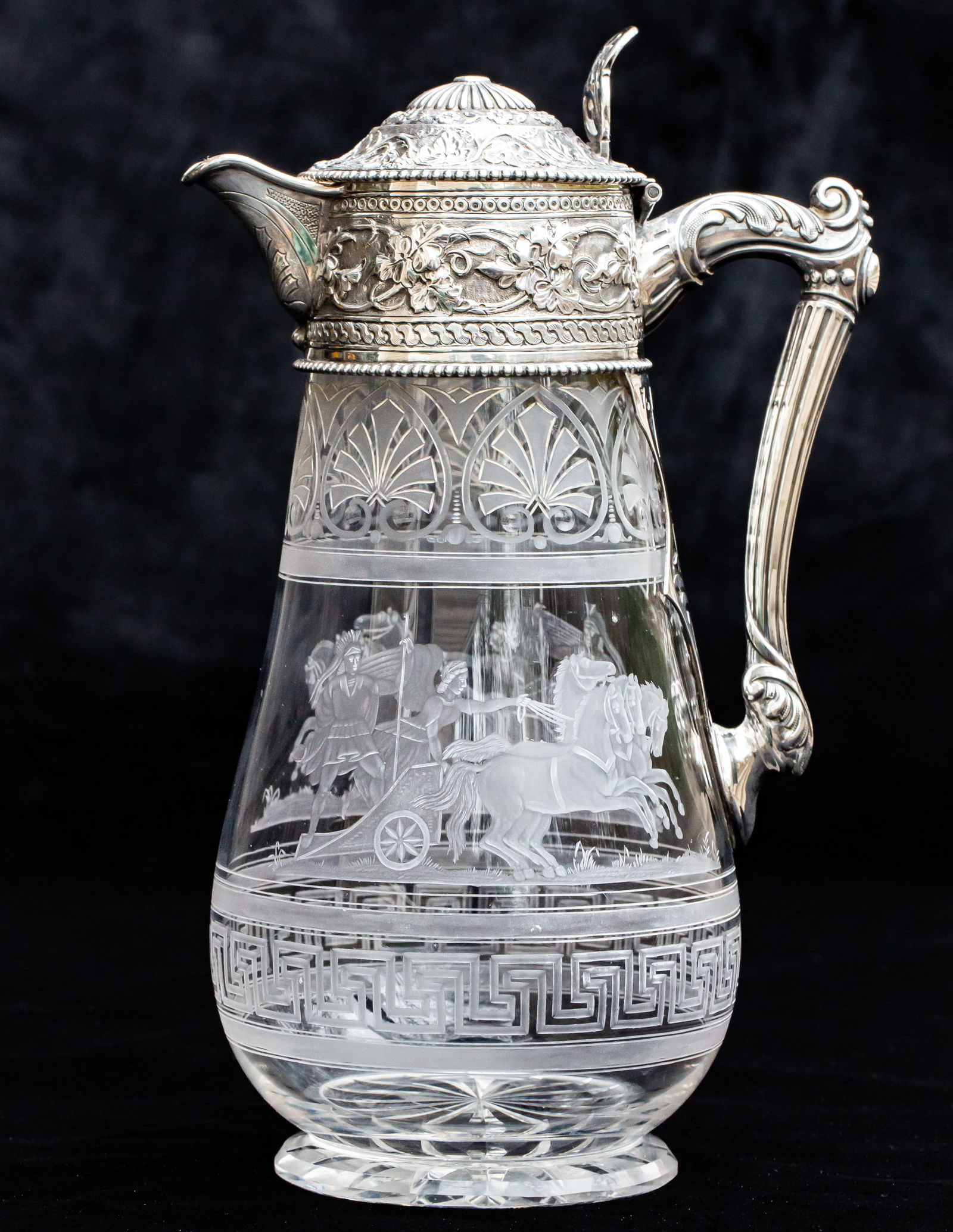 Wonderfully Engraved Brilliant Period Cut Glass Ewer w/ Sterling Silver: The engraving and silver work on this piece are just stunning. The engraving features the Greek goddess Victory (Nike) alongside what would be the king (likely roman) riding a chariot pulled by four b