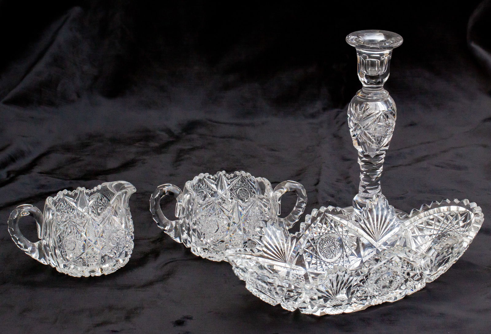 Group of 4 American Brilliant Cut Glass Items - Cream and Sugar, Tray, Candlestick: All pieces with significant damage - chip to lip to candlestick, chips throughout the tray, and handle cracks to both handles of the sugar bowl